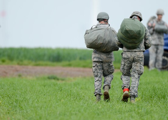 Master Sgt. Kevin Angell, Special Operations Command Korea, NCO in charge of communications directorate (left) and Tech. Sgt. Brian Angell, 435th Contingency Response Group personnel parachute program manager, Tucson, Arizona, natives, walk off the drop zone after they landed a 1,250 ft static-line jump, during International Jump Week in Alzey landing zone, Germany, May 8, 2014. Brian Angell flew in from Korea to jump with his younger brother for the first time in both of their careers. (U.S. Air Force photo/Airman 1st Class Michael Stuart)