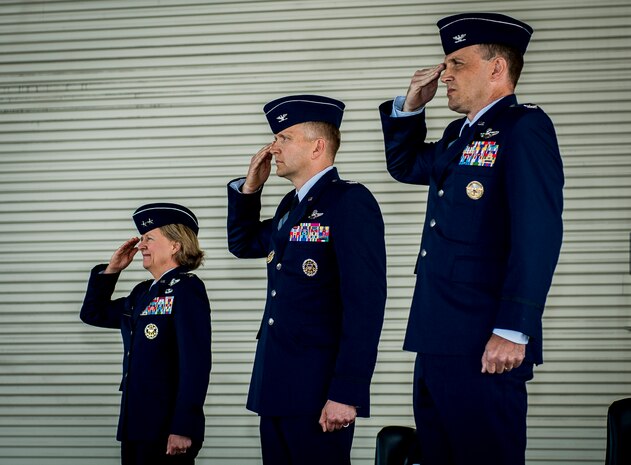 Maj. Gen. Barbara Faulkenberry, 18th Air Force commander, Col. Darren Hartford and Col. John Lamontagne, salute the American flag during the National Anthem before the 437th Airlift Wing change of Command ceremony on May 22, 2014, in Nose Dock 2 at Joint Base Charleston - Air Base, S.C. (U.S. Air Force photo/Senior Airman Dennis Sloan)