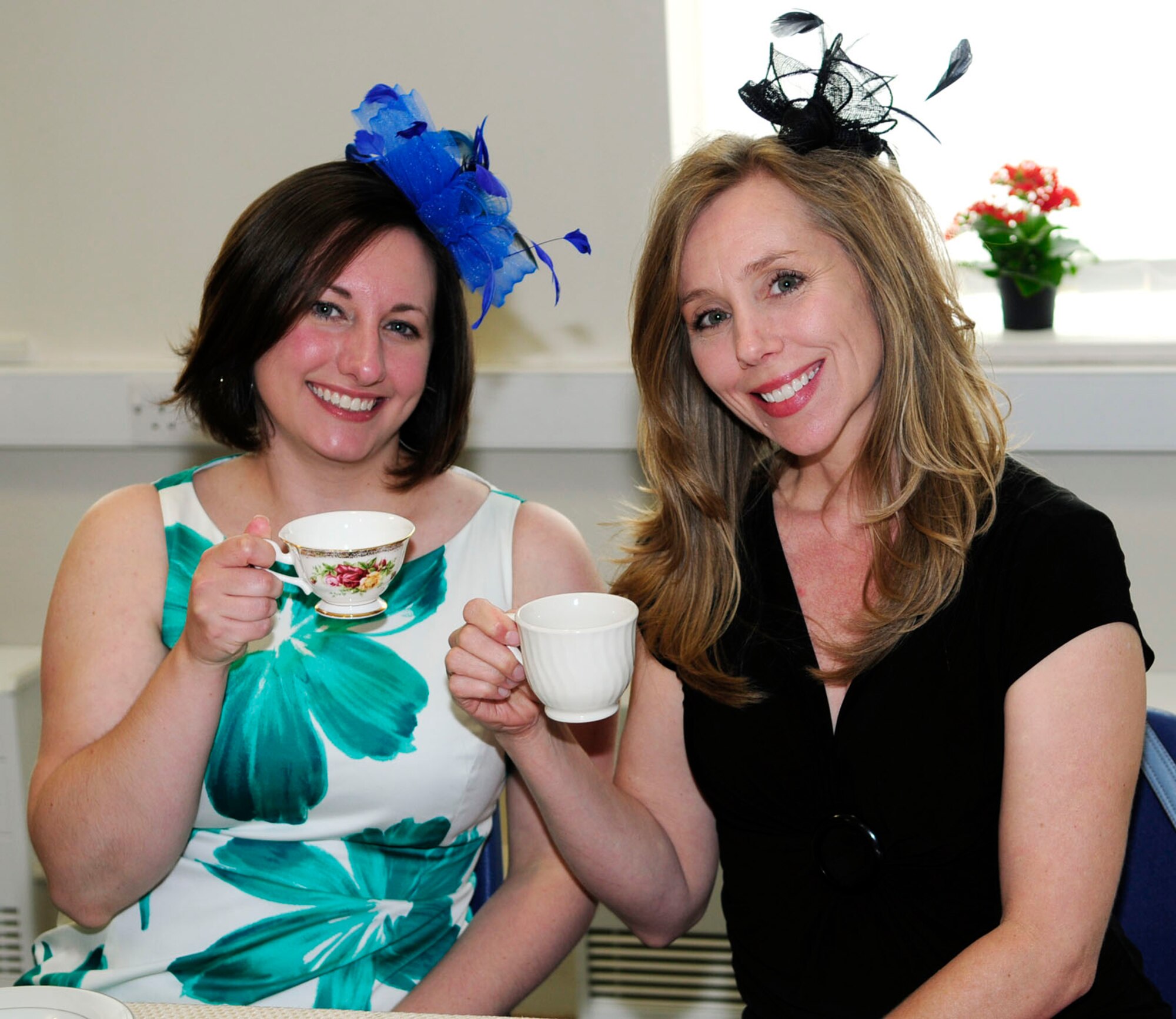 Sarah Allan, left, 352nd Special Operations Support Squadron spouse from Harwinton, Conn., and Robyn Peterson, 7th Special Operations Squadron spouse from Columbus, Miss., drink tea and show off their hats at the Military Spouse Appreciation Day High Tea May 20, 2014, at the chapel on RAF Mildenhall, England. Thirty-five spouses got together for scones, sandwiches, tea, chocolates and chat as they partook in one of the several events held throughout the day in their honor. (U.S. Air Force photo by Karen Abeyasekere/Released)
