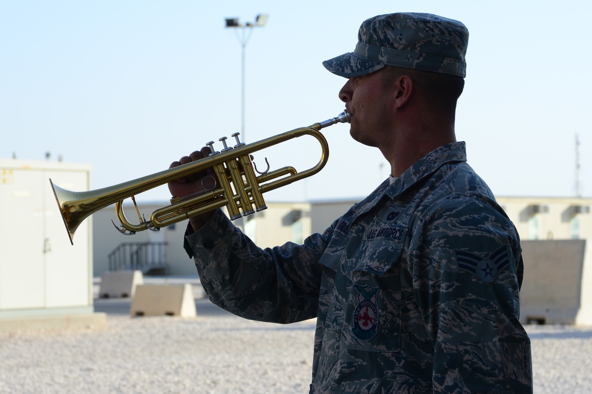 U.S. Air Force Senior Airman James Giles plays Taps during a retreat ceremony at Al Udeid Air Base, Qatar, May 16, 2014. The ceremony was held as part of National Police Week to pay respect for all fallen service members. Giles is deployed from MacDill Air Force Base and hails from Knob Noster, Missouri. (U.S. Air Force Photo by Master Sgt. Marcelo Joniaux)     