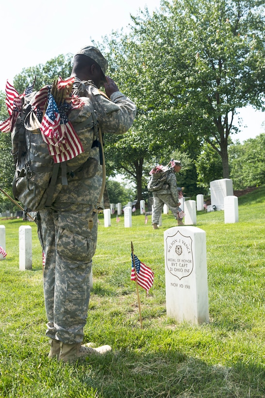 A soldier salutes the grave of a Medal of Honor winner during the ...