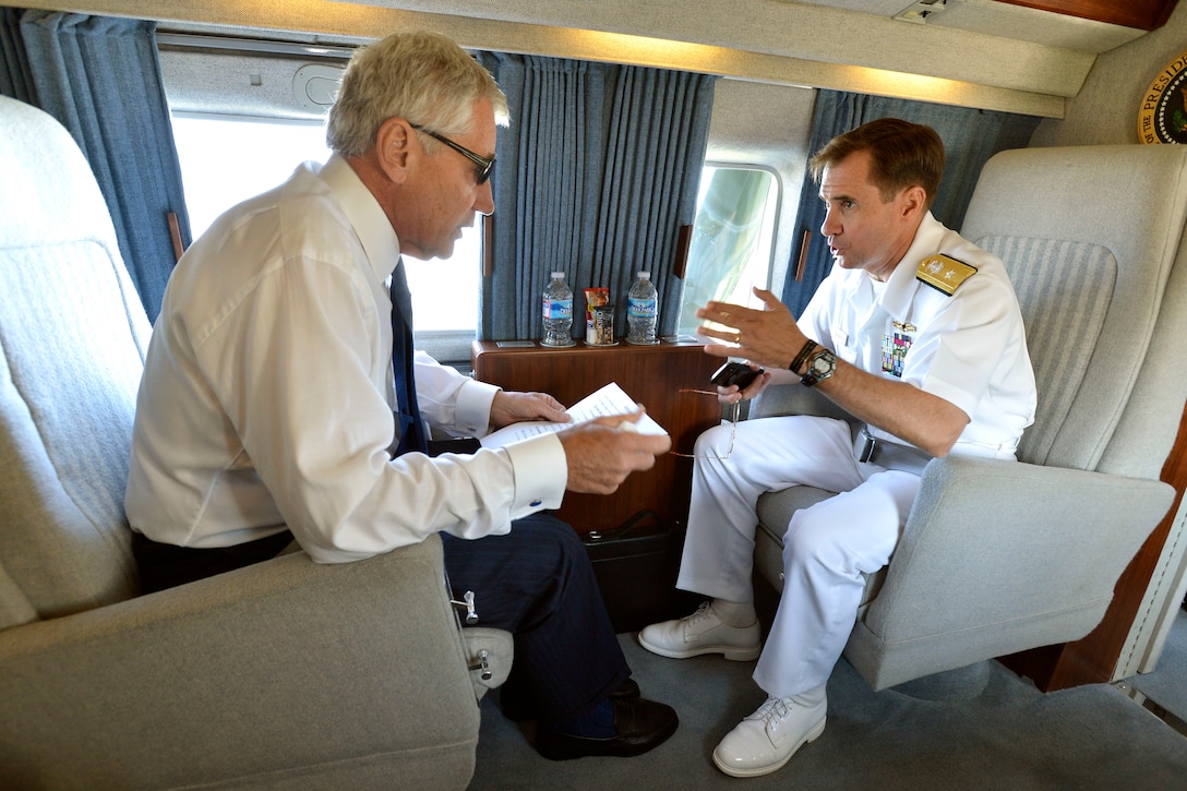 Defense Secretary Chuck Hagel confers with Pentagon Press Secretary Navy Rear Adm. John Kirby as they travel in a Marine helicopter to attend commencement ceremonies at the U.S. Naval Academy in Annapolis, Md., May 23, 2014.