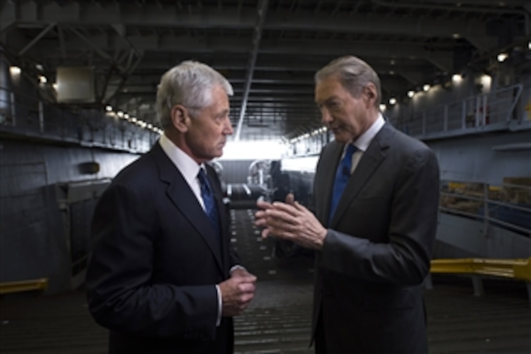 Defense Secretary Chuck Hagel, left, talks with Charlie Rose, journalist and anchor of the "Charlie Rose Show," during an interview aboard the amphibious dock landing ship USS Oak Hill in New York, May 22, 2014. Hagel later received the 2014 Intrepid Freedom Award at the Intrepid Sea, Air and Space Museum.