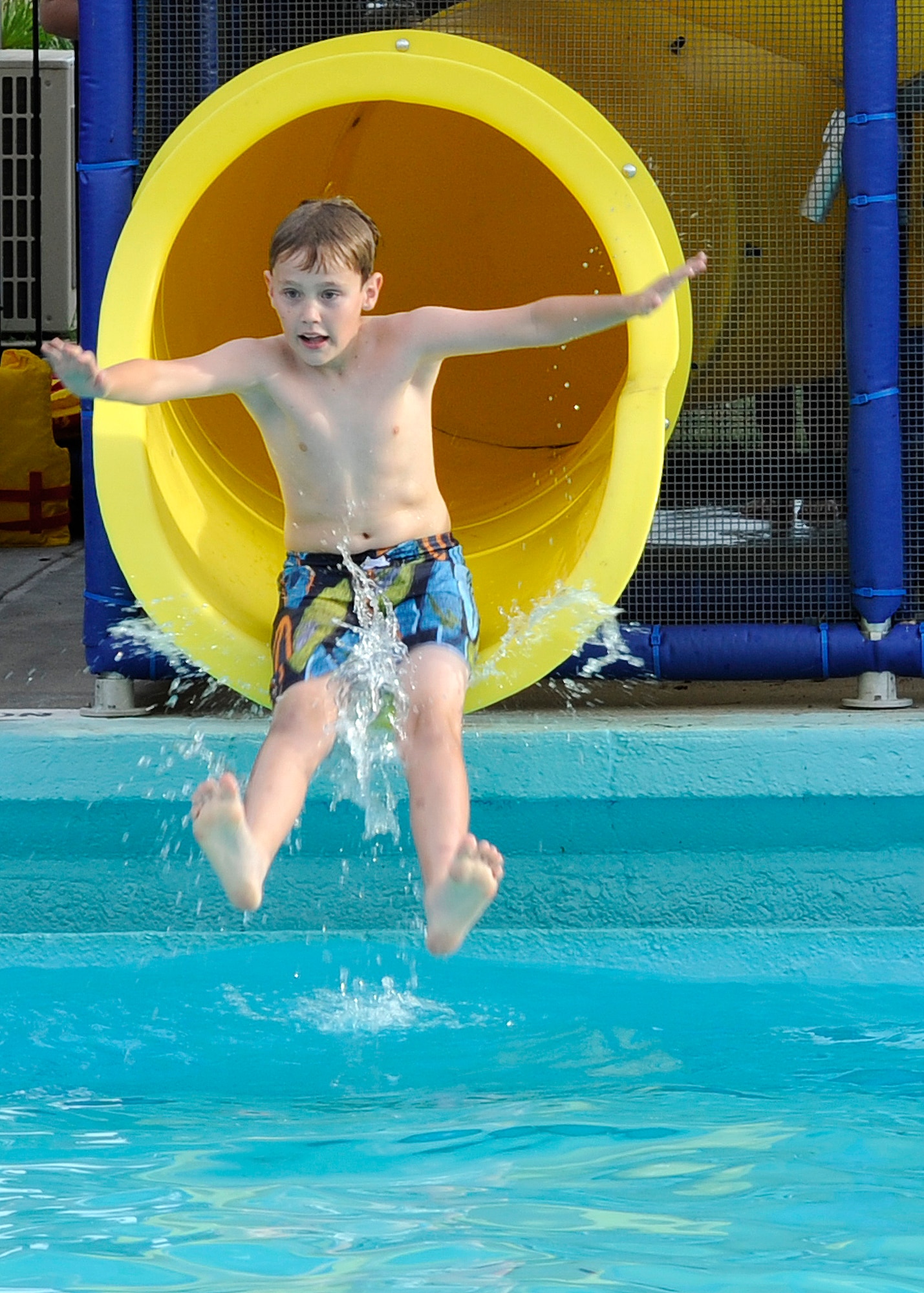 Kallen Zhea, son of Lt. Col. Kristian Zhea, 412th Security Forces Squadron commander, Edwards Air Force Base, Ca., slides down a waterslide during the Pool Bash at the North Gate Pool on Barksdale Air Force Base, La., May 23, 2014. Pool Bash guests not only enjoyed four different waterslides, but also received free admission, food and drinks while celebrating the opening of the pool for the summer season. (U.S. Air Force photo/Senior Airman Joseph A. Pagán Jr.)