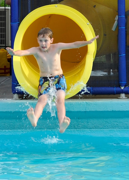 Kallen Zhea, son of Lt. Col. Kristian Zhea, 412th Security Forces Squadron commander, Edwards Air Force Base, Ca., slides down a waterslide during the Pool Bash at the North Gate Pool on Barksdale Air Force Base, La., May 23, 2014. Pool Bash guests not only enjoyed four different waterslides, but also received free admission, food and drinks while celebrating the opening of the pool for the summer season. (U.S. Air Force photo/Senior Airman Joseph A. Pagán Jr.)