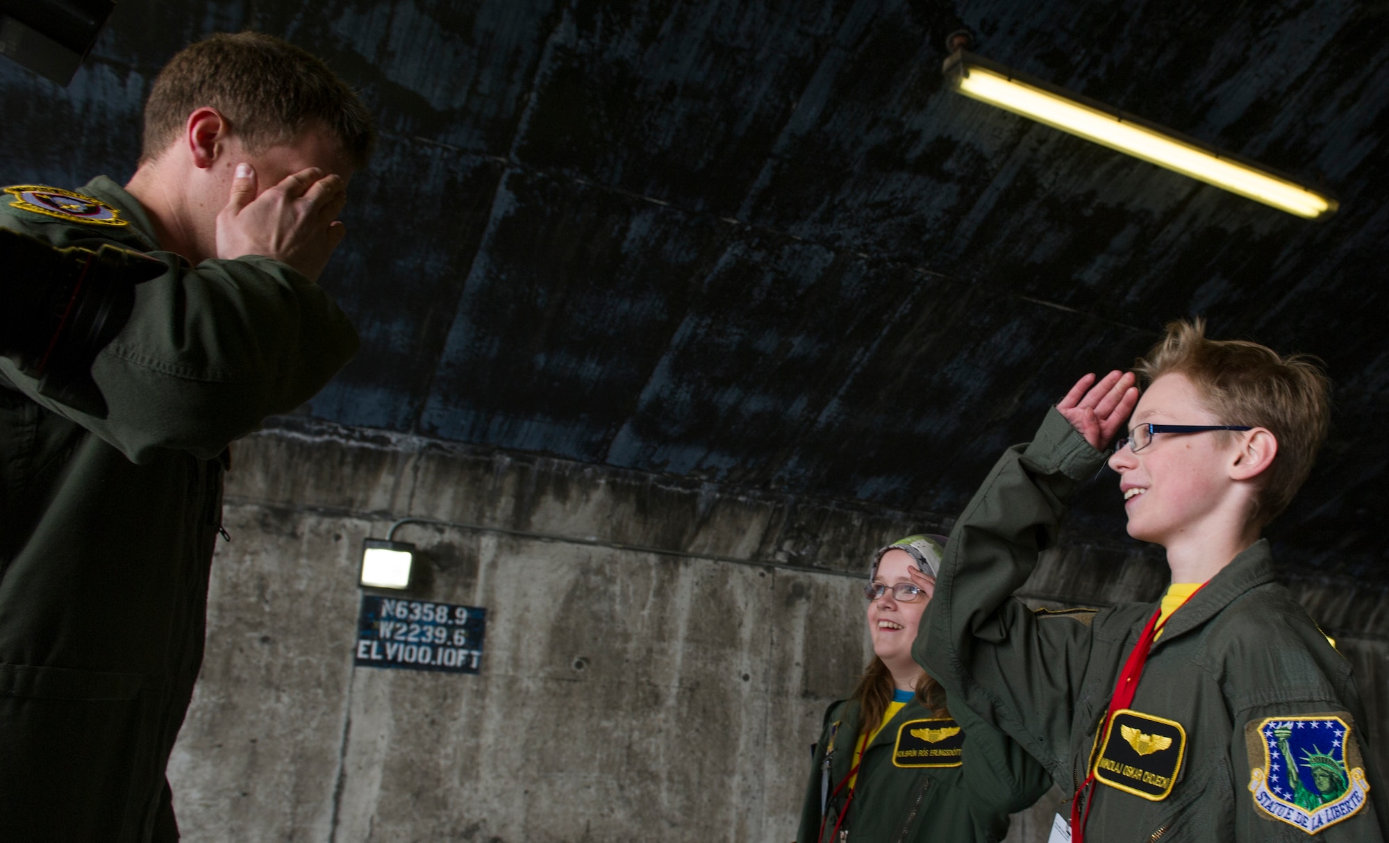 KEFLAVIK, Iceland -- Mikolaj Chojecki (right), 14, and Kolbrun Erlendsdottir, 11, receive their first salute from Capt. Matt Tanis, 48th Air Expeditionary Group F-15C Eagle pilot, after receiving their flight wings during the pilot-for-a-day program at Keflavik International Airport May 23, 2014. Airmen deployed with the 48th AEG took time out of their day to brighten the lives of the two children who have been struggling with serious long-term illnesses. (U.S. Air Force photo/Tech. Sgt. Benjamin Wilson)(Released)