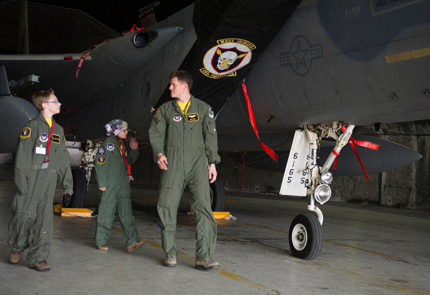 U.S. Air Force Capt. Matt Tanis, 48th Air Expeditionary Group F-15C Eagle pilot, explains the function of an F-15C Eagle to Mikolaj Chojecki, 14, and Kolbrun Erlendsdottir, 11, during the pilot-for-a-day program May 23, 2014, at Keflavik International Airport in Iceland. Airmen deployed with the 48th AEG took time out of their day to brighten the lives of the two children who have been struggling with serious long-term illnesses. (U.S. Air Force photo by Tech. Sgt. Benjamin Wilson/Released) 