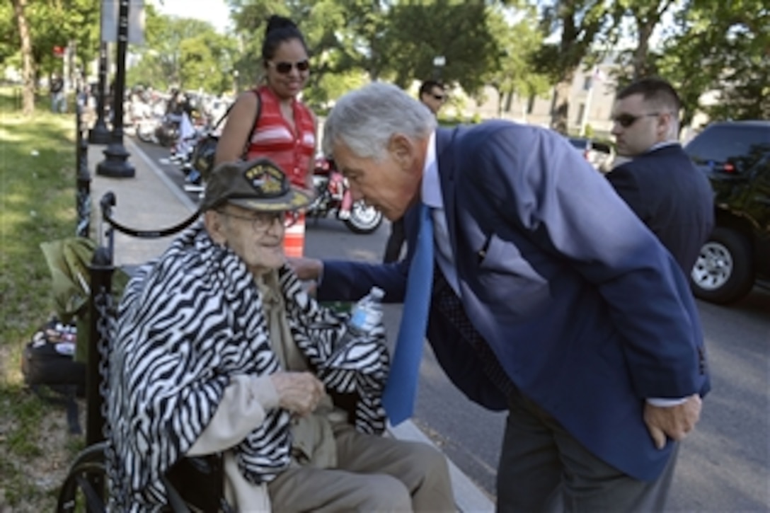 Defense Secretary Chuck Hagel, right, stops to chat with veteran Peter P. Ruplenas as he arrives at the Vietnam Veterans Memorial to deliver remarks at the National Reading of the Names: Post 9/11 Heroes ceremony in Washington, D.C., May 24, 2014. Ruplenas served during World War II, the Korean War and Vietnam War as a combat photographer.