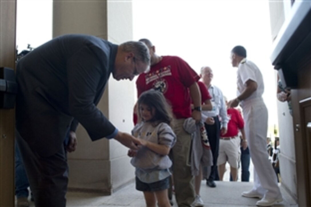 Deputy Defense Secretary Bob Work greets a young girl during a Tragedy Assistance Program for Survivors event at the Pentagon, May 23, 2014. TAPS families toured the Pentagon, where they saw different exhibitions from the Navy, Army, Marine Corps and Air Force. The program provides support and resources to grieving military families. 