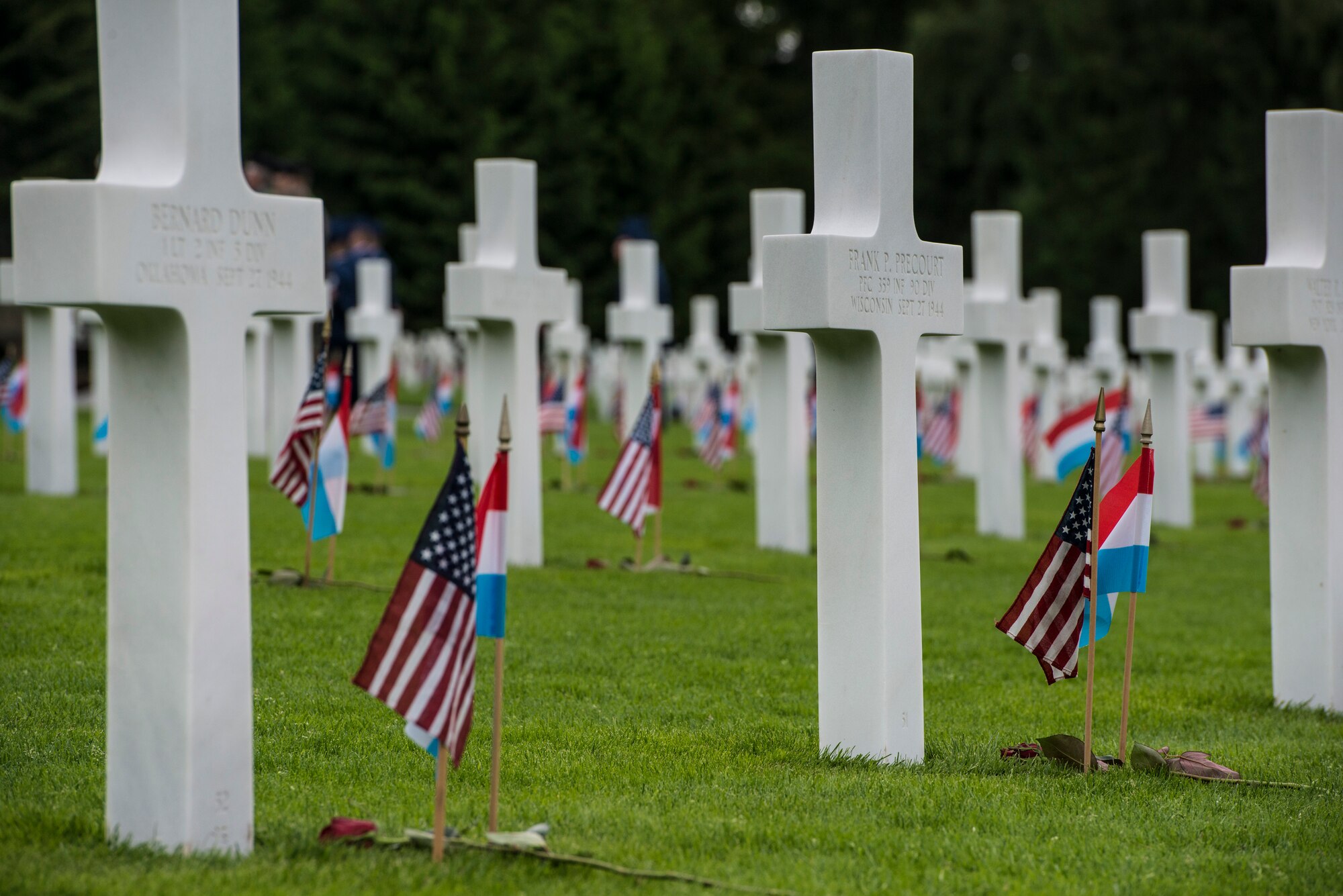 U.S. and Luxembourg flags are placed at the head stones of more than 5,000 fallen World War II service members during a Memorial Day ceremony at the Luxembourg-American Military Cemetery and Memorial, Luxembourg, May 24, 2014. Memorial Day commemorates the men and women who have died while in military service. (U.S. Air Force photo by Staff Sgt. Christopher Ruano/Released)