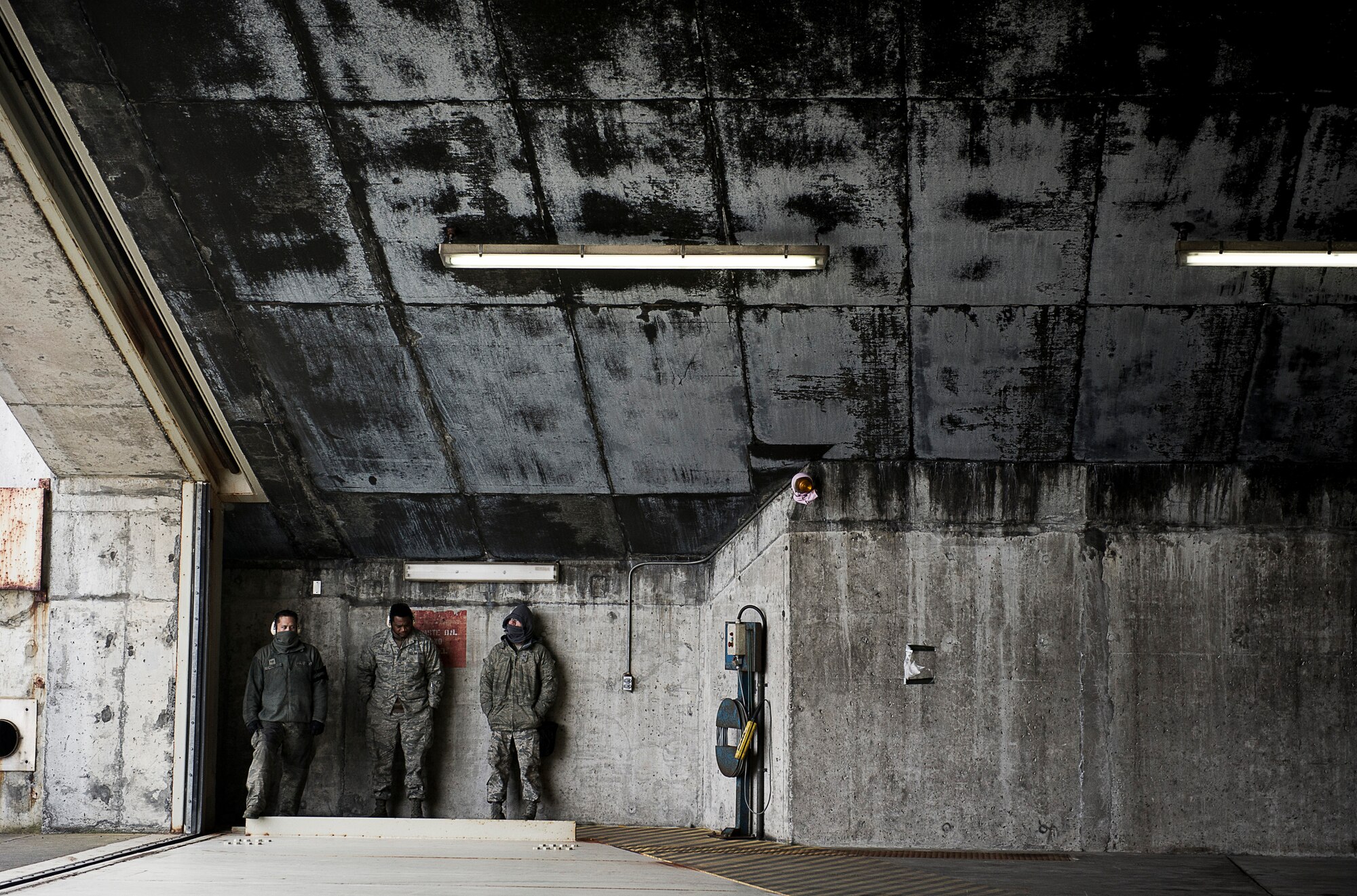 KEFLAVIK, Iceland -- Maintainers deployed with the 48th Air Expeditionary Group hide from icy wind and rain before preparing an F-15C Eagle for take off at Keflavik International Airport May 15, 2014. The Airmen are deployed for Icelandic Air Policing, which is part of NATO's commitment to keep Iceland’s airspace safe and secure. (U.S. Air Force photo/Tech. Sgt. Benjamin Wilson)(Released)