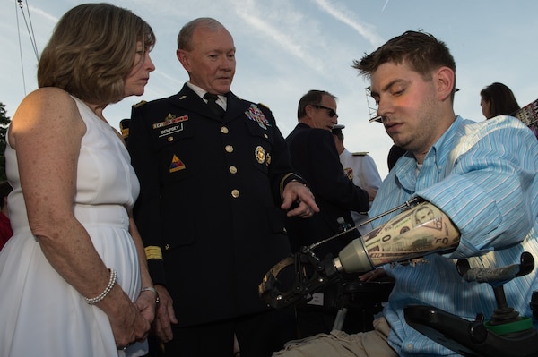 Gen. Martin E. Dempsey, chairman of the Joint Chiefs of Staff, and his wife Deanie, talk with John Peck, a former Marine Sergeant and Wounded Warrior, prior to the 25th National Memorial Day Concert on the West Lawn of the U.S. Capitol in Washington, D.C., May 25, 2014. Peck’s story of resiliency was shared during the concert, along with other dramatic readings to pay tribute to their sacrifices as well as those of their families and loved ones.