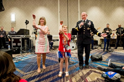 Army Gen. Martin E. Dempsey, chairman of the Joint Chiefs of Staff, and his wife, Deanie, sing during the annual Tragedy Assistance Program for Survivors, or TAPS, National Military Survivor Seminar and Good Grief Camp for children in Arlington, Va., May 23, 2014. In addition to singing, Dempsey addressed surviving family members of fallen service members.