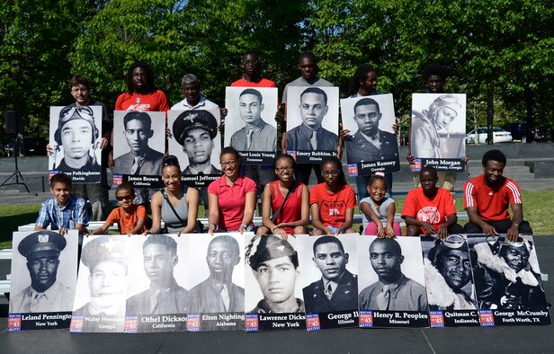 Young volunteers representing the East Coast Chapter of the Tuskegee Airmen Inc. participated in a Memorial Day wreath-laying ceremony held May 26, 2014, at the Air Force Memorial, in Arlington, Va. Chief Master Sgt. of the Air Force James A. Cody provided the keynote speech remarking that for him, on Memorial Day, the three spires of the memorial stood for freedom, fortitude and our fallen. He went on to say that today is a day to remember the freedom that we all share because of the fortitude shown by of our fallen comrades in fighting and standing their ground. Cody then told the crowd that today, and everyday, our fallen are with us in our stories and our memories, and they give us cause to wave our flags. (U.S. Air Force photo/Jim Varhegyi)