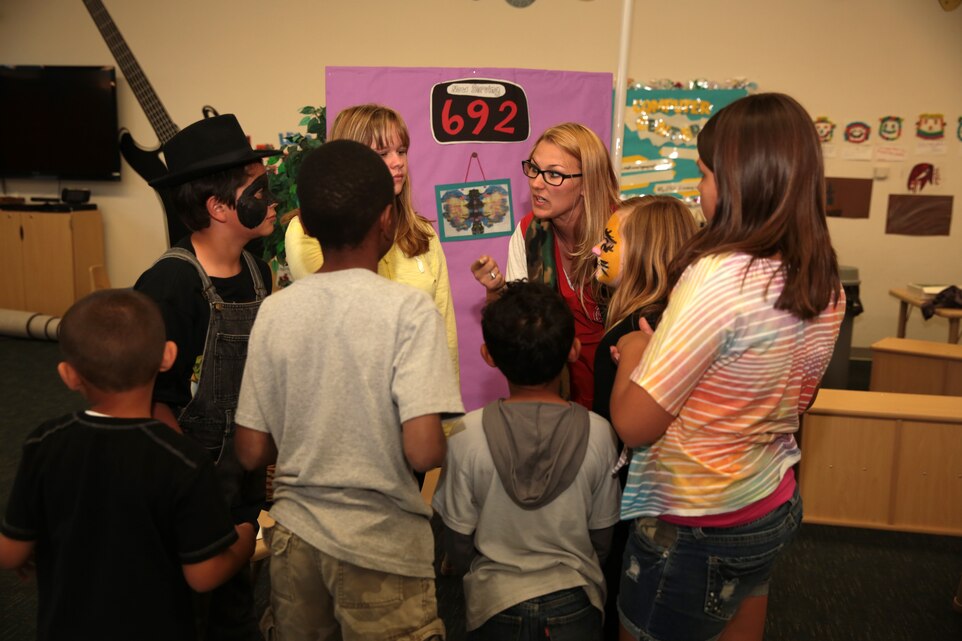 Shelby Bessette, program assistant, School Age Care, Child Development Center, gives the performers a final pep talk before they perform the Superhero Support Group skit in the Mustang Room of the Child Development Center, April 16, 2014.