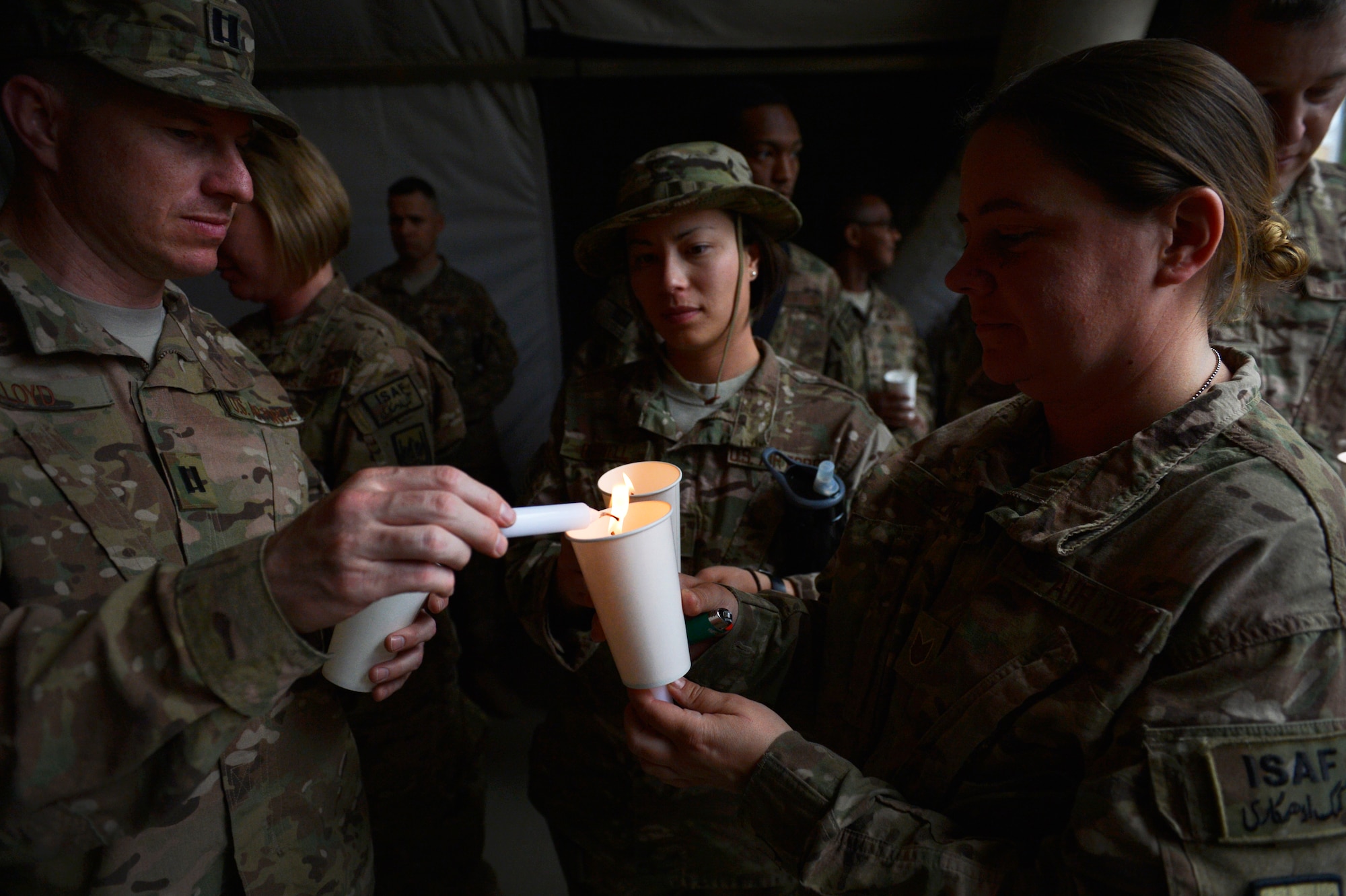 U.S. Air Force Airmen light a candle during a Memorial Day candle vigil May 26, 2014 at Bagram Airfield, Afghanistan.  Memorial Day is observed annually on the last Monday of May to commemorate the men and women
who died while serving in the U.S. Armed Forces. (U.S. Air Force photo by Staff Sgt. Evelyn Chavez/Released)