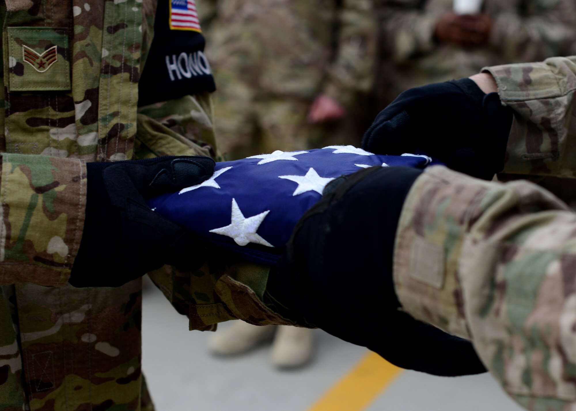 U.S. Air Force Airmen fold a flag during in a Memorial Day candle vigil May 26, 2014 at Bagram Airfield, Afghanistan.  Memorial Day is observed annually on the last Monday of May to commemorate the men and women who died while serving in the U.S. Armed Forces. (U.S. Air Force photo by Staff Sgt. Evelyn Chavez/Released)