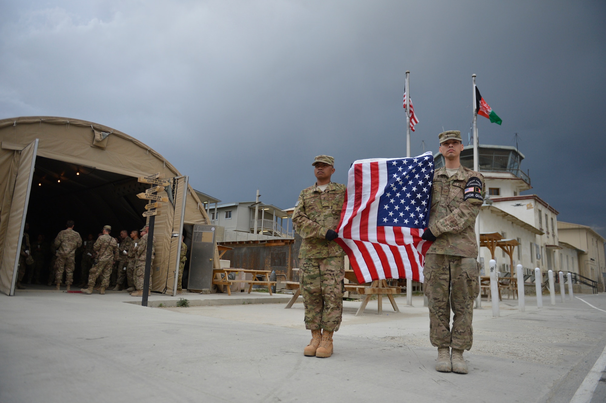 Senior Airman Jerick Encarnacion and Staff Sgt. Carlos Carvajal Molina, 455th Expeditionary Logistics Readiness Squadron, hold a flag during a Memorial Day candle vigil march May 26, 2014 at Bagram Airfield, Afghanistan. Memorial Day is observed annually on the last Monday of May to commemorate the men and women who died while serving in the U.S. Armed Forces. Carvajal Molina is deployed from Travis Air Force Base, Calif. and native of Torrance, Calif. Encarnacion is deployed from Eielson Air Force Base, Alaska and a native of Vallejo, Calif. (U.S. Air Force by Staff Sgt. Evelyn Chavez/Released)