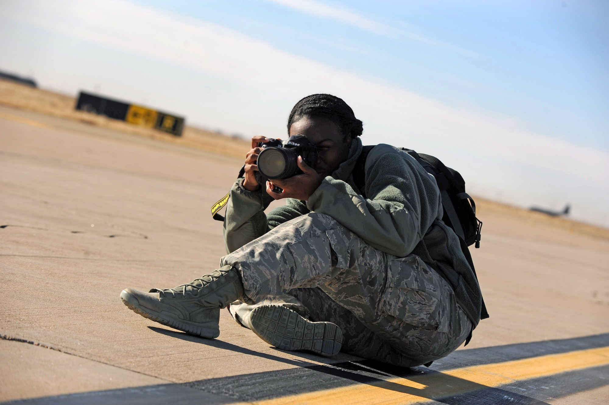 U.S Air Force Senior Airman Eboni Reece, 27th Special Operations Wing Public Affairs photojournalist, captures images of aircraft taking off on the flightline January 16, 2014 at Cannon Air Force Base, N.M. Reece, originally trained as a still photographer, has captured thousands of images during her tenure at Cannon. (U.S. Air Force photo/ Airman 1st Class Chip Slack)
