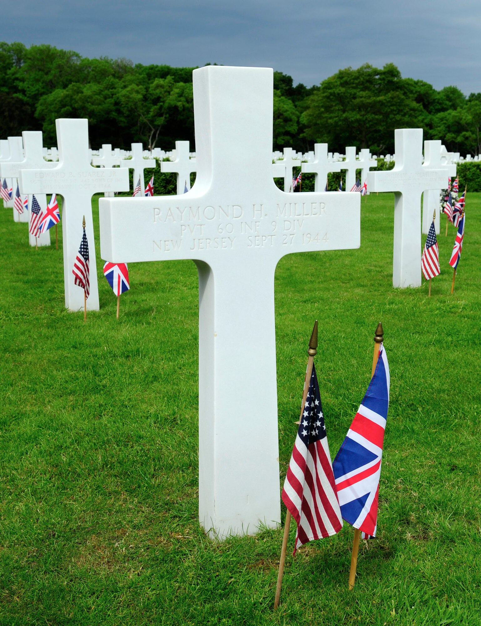 Headstones made of Lasa marble line the grounds of Madingley American Cemetery May 26, 2014, at Madingley, near Cambridge, England. British and American flags were posted at the foot of each of the 3,812 graves in honor of Memorial Day. Memorial Day is an annual tradition honoring fallen service members. (U.S. Air Force photo by Karen Abeyasekere/Released)
