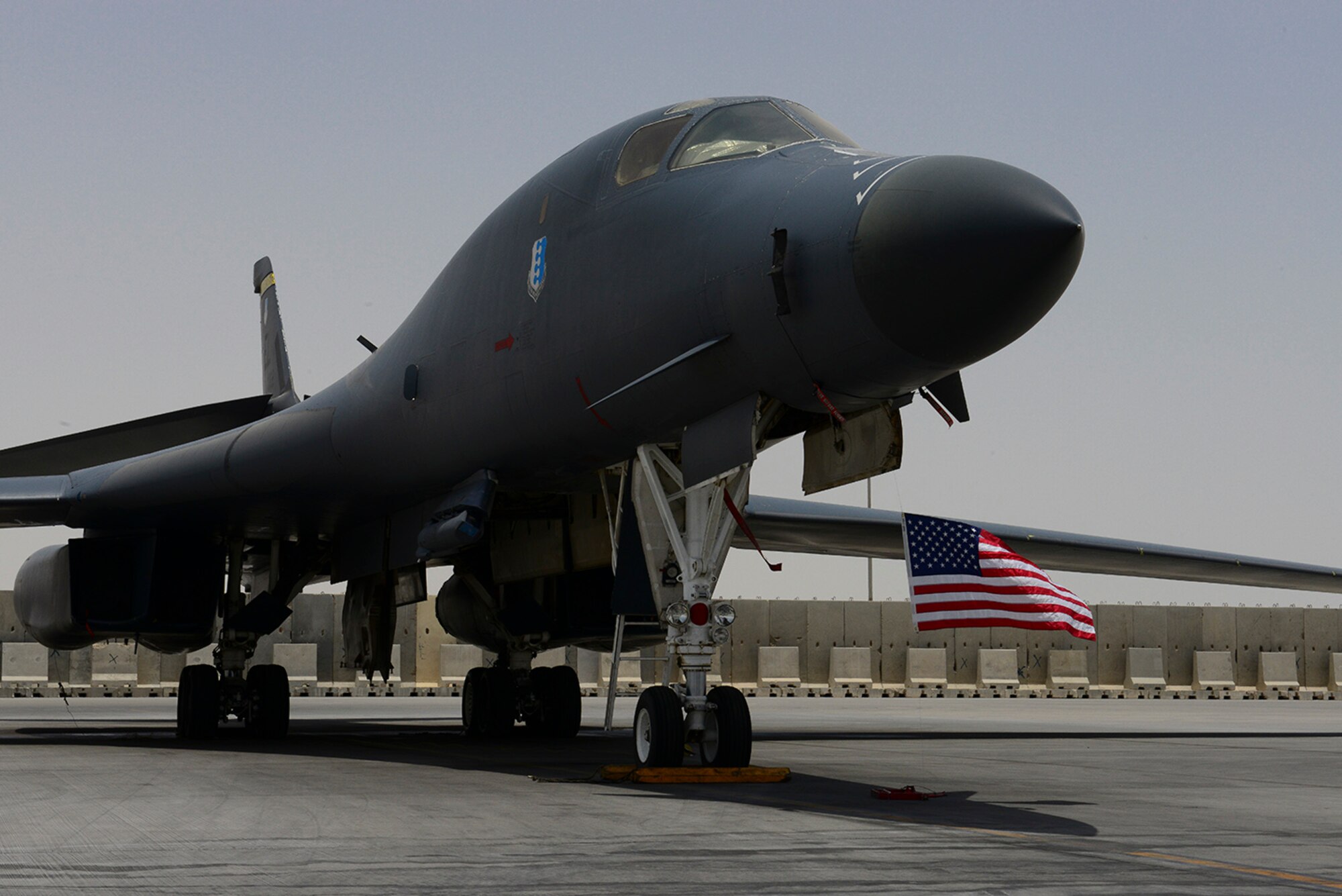 A B1 Lancer is parked on the flight line at Al Udeid Air Base, Qatar, May 26, 2014. The aircraft is pictured with an American flag, to honor Memorial Day, a day in which we honor Service members that have made the ultimate sacrifice. (U.S. Air Force photo by Staff Sgt. Ciara Wymbs)