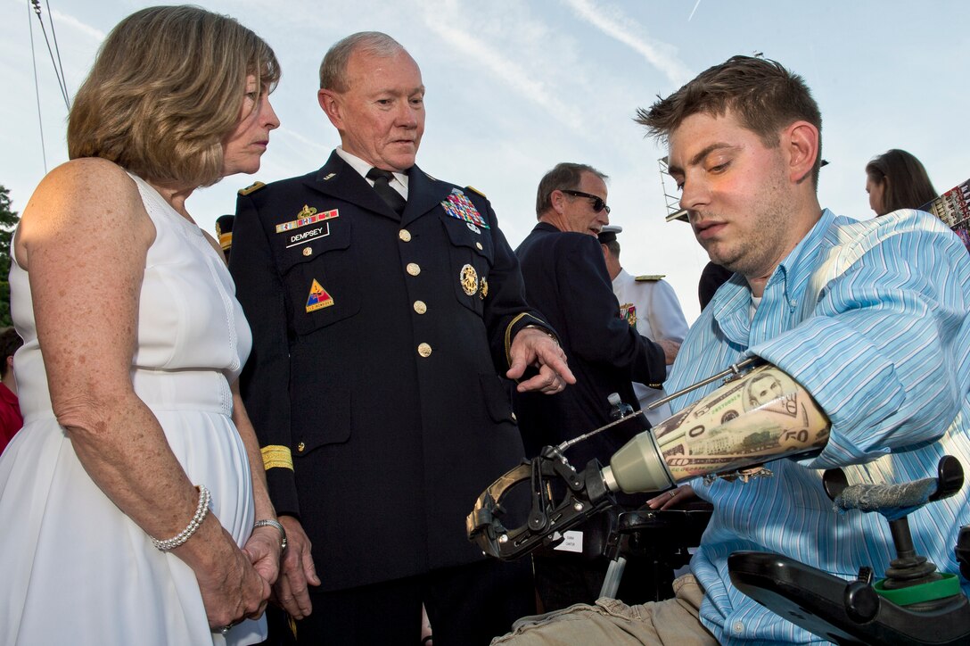 Army Gen. Martin E. Dempsey, chairman of the Joint Chiefs of Staff, and his wife, Deanie, talk with former Marine Corps Sgt. John Peck before the National Memorial Day Concert at the U.S. Capitol in Washington, D.C., May 25, 2014. 