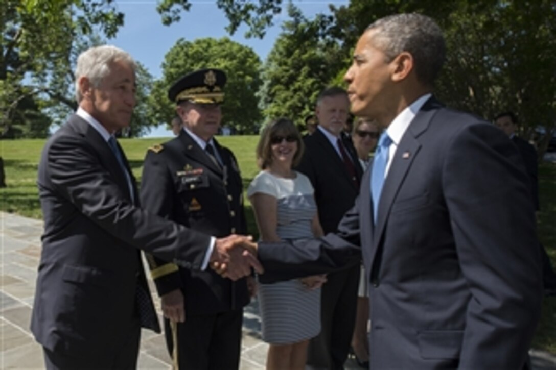 Defense Secretary Chuck Hagel and Army Gen. Martin E. Dempsey, chairman of the Joint Chiefs of Staff, greet President Barack Obama as they gather to mark Memorial Day at Arlington National Cemetery in Arlington, Va., May 26, 2014. Obama participated in a wreath-laying ceremony at the Tomb of the Unknowns to honor the fallen before he, Hagel and Dempsey spoke to about 3,000 people in the cemetery's Memorial Amphitheater.