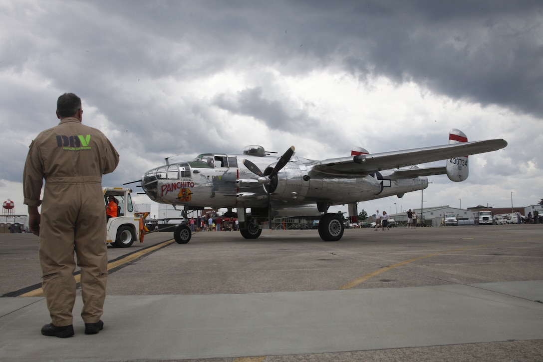 A member of the Disabled American Veterans Flight Team directs an aircraft tug on the flight line while it tows “Panchito,” a B-25 Mitchell bomber, during the 2014 Marine Corps Air Station Cherry Point Air Show May 18. Founded in 1920, the DAV uses the aircraft to promote their cause – providing support and services to veterans. 