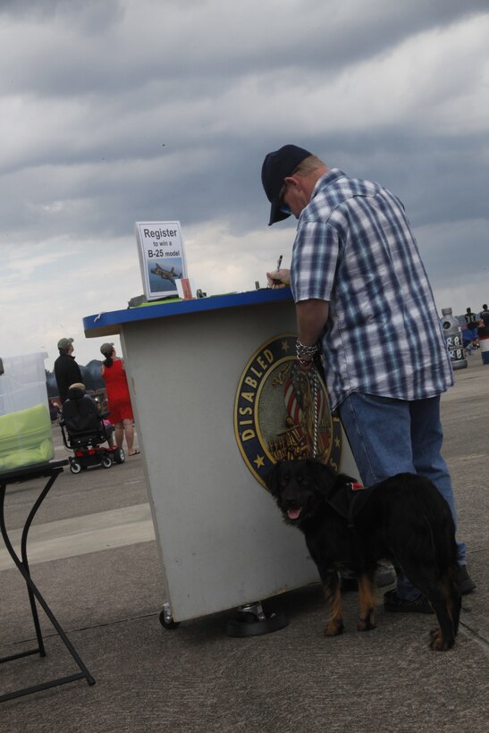 A visitor of the 2014 Marine Corps Air Station Cherry Point Air Show fills out information at the Disabled American Veterans booth on the flight line May 18. Founded in 1920, the DAV organization uses a B-25 Mitchell bomber "Panchito" to promote their cause – providing support and services to veterans. 