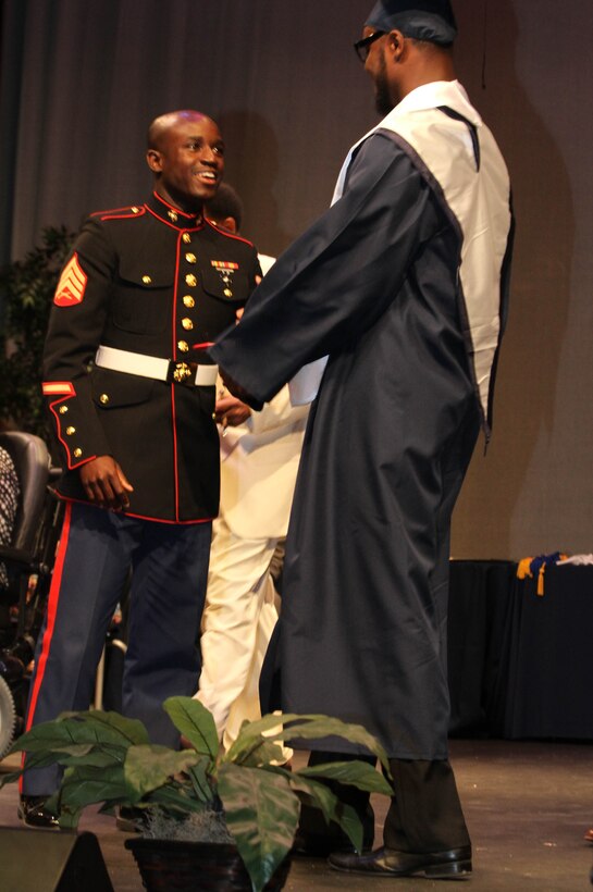 U.S. Marine Corps Sgt. Ivey Brooks, a recruiter with Recruiting Sub-Station Durham, Marine Corps Recruiting Station Raleigh, and Durham, N.C., native, presents Trevion Thompson, a wide receiver for the Hillside High School football team, with a certificate for his participation in the Semper-Fi All-American Bowl during the Hillside High School 65th Annual Awards Ceremony at Hillside High School in Durham, N.C., May 22, 2014. Thompson was selected to play in the SFAAB for his skill as a wide receiver, his academics and his leadership ability. The SFAAB honored selected players who demonstrated the Marine Corps’ commitment to developing quality citizens, and reinforced our core values of honor, courage, and commitment, on and off the field.   Like the Marine Corps, the Semper Fidelis Football Program demanded quality of character, excellence in education, and proven physical fitness (U.S. Marine Corps photo by Sgt. Dwight A. Henderson/Released)