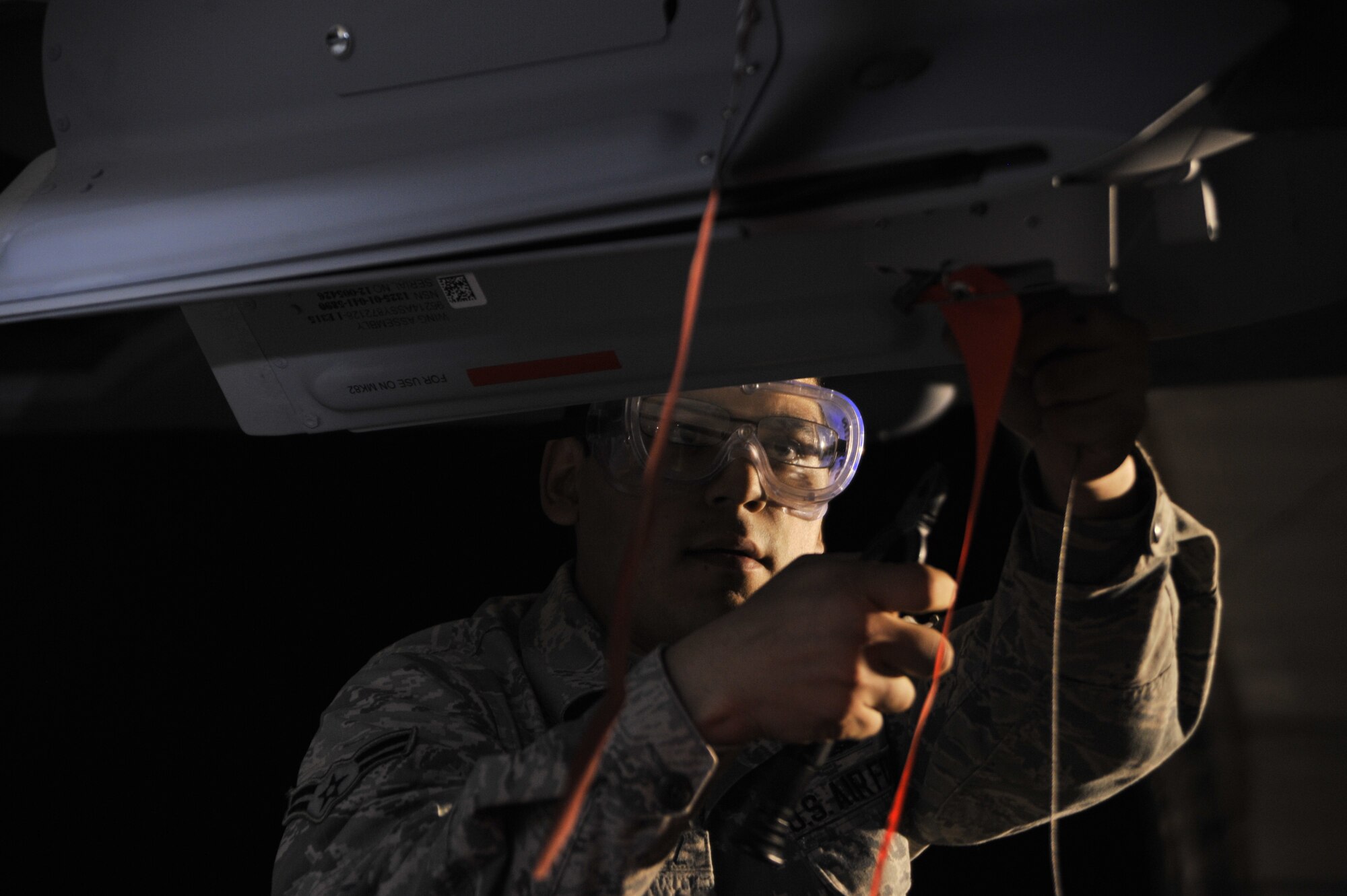 Airman 1st Class Luis safety wires a GBU-12 Paveway II laser-guided bomb onto an MQ-9 Reaper during exercise Combat Hammer May 15, 2014, at Creech Air Force Base, Nev. Fighter, bomber and remotely piloted aircraft units around the Air Force are evaluated four times a year and provided weapons, airspace and targets from Hill AFB, Utah, or Eglin AFB, Fla. Luis is a load crew member with the 432nd Aircraft Maintenance Squadron. (U.S. Air Force photo/Airman 1st Class C.C.)
