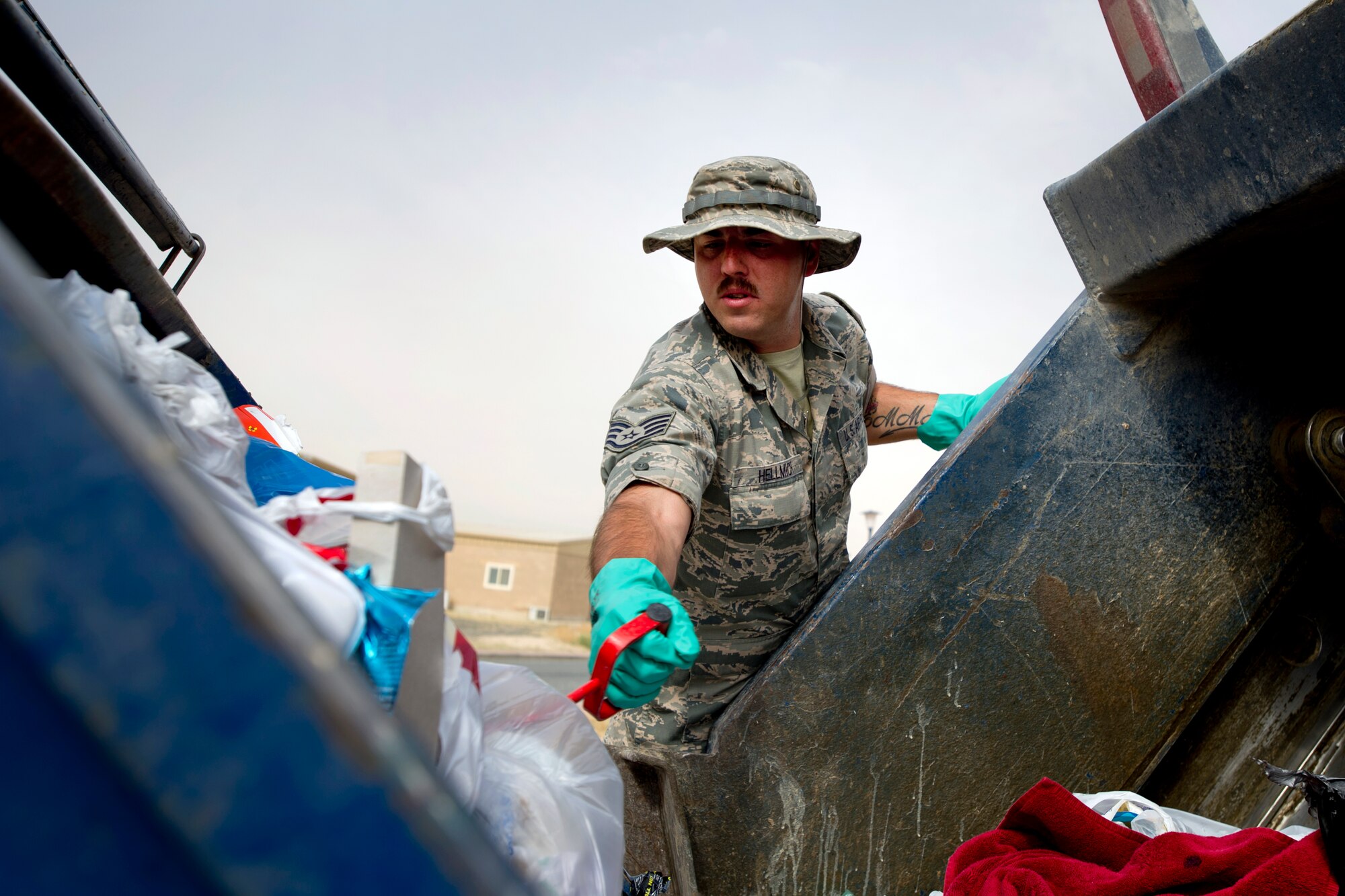 Staff Sgt. Joshua Hellmich sorts through a dumpster of trash looking for OPSEC violations April 18, 2014, in Southwest Asia. Through these inspections and the uniform collection bins, almost 1.5 tons of unserviceable uniform items were collected during the past year and set aside for destruction.  The uniforms were destroyed to ensure they do not end up being utilized improperly if discarded with normal trash.  Hellmich is a member of the force protection flight of the 386th Expeditionary Civil Engineer Squadron. (U.S. Air Force photo/Senior Master Sgt. Burke Baker)
