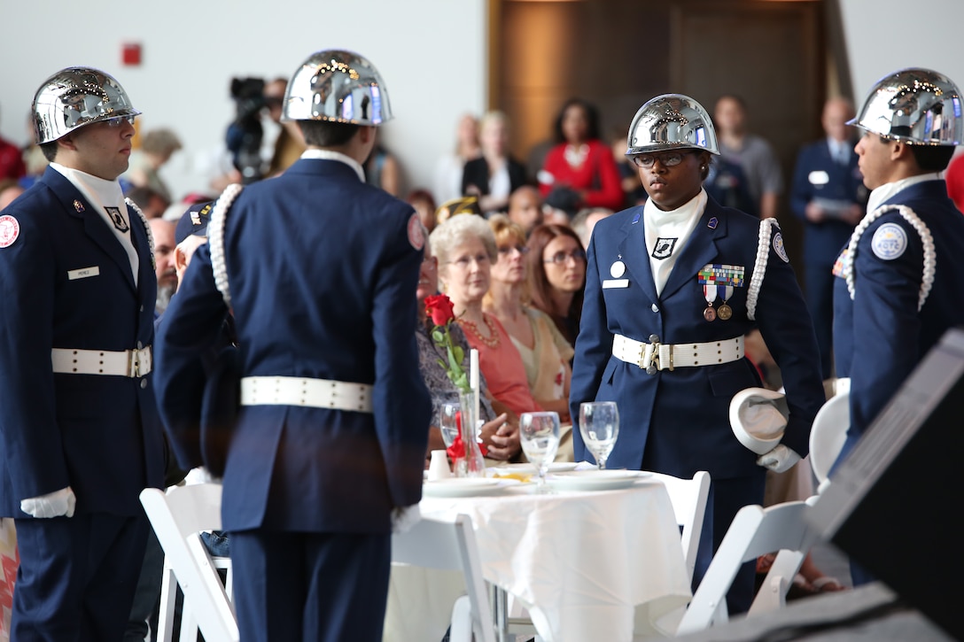 The Riverdale High School Air Force Junior Reserve Officer Training Corps cadets perform a fallen hero’s table setting ceremony, placing the uniform cover of each military branch at empty seats at the table, to symbolize the fallen from each service, at a memorial service in the Boeing exhibit of the National World War II Museum in New Orleans, Louisiana, May 26, 2014. The ceremony honored members of the military who made the ultimate sacrifice for their country, and was attended by many veterans and family members.