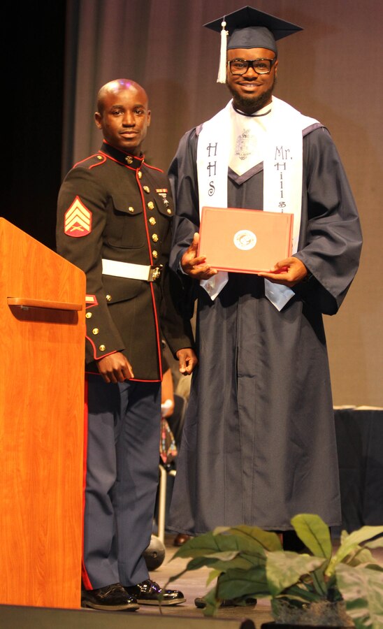 U.S. Marine Corps Sgt. Ivey Brooks, a recruiter with Recruiting Sub-Station Durham, Marine Corps Recruiting Station Raleigh, and Durham, N.C., native, poses for a picture with Trevion Thompson, a wide receiver for the Hillside High School football team, after presenting Thompson with a certificate for his participation in the Semper-Fi All-American Bowl during the Hillside High School 65th Annual Awards Ceremony at Hillside High School in Durham, N.C., May 22, 2014. Thompson was selected to play in the SFAAB for his skill as a wide receiver, his academics and his leadership ability. The SFAAB honored selected players who demonstrated the Marine Corps’ commitment to developing quality citizens, and reinforced our core values of honor, courage, and commitment, on and off the field.   Like the Marine Corps, the Semper Fidelis Football Program demanded quality of character, excellence in education, and proven physical fitness (U.S. Marine Corps photo by Sgt. Dwight A. Henderson/Released)