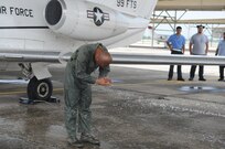 Lt. Col. Gavin P. Marks, 99th Flying Training Squadron commander, is hosed down after completing his fini flight at Joint Base San Antonio-Randolph, Texas, May 27, 2014.  Marks completed his fini flight, which is a time honored military aviation tradition marking the end  of a pilot's or commander's time at a location or command. (U.S. Air Force photo by Dona Fair)