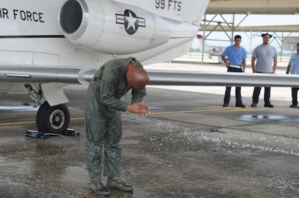 Lt. Col. Gavin P. Marks, 99th Flying Training Squadron commander, is hosed down after completing his fini flight at Joint Base San Antonio-Randolph, Texas, May 27, 2014.  Marks completed his fini flight, which is a time honored military aviation tradition marking the end  of a pilot's or commander's time at a location or command. (U.S. Air Force photo by Dona Fair)