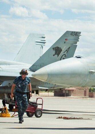 U.S. Navy Petty Officer 3rd class Jefferson Metzen, plane captain assigned to Strike Fighter Squadron 131, surveys an F/A-18C Hornet on May 21, 2014, at Nellis Air Force Base, Nev. Metzen performs the surveys to ensure the area is safe for the pilot to conduct their preflight checks. Green Flag air-to-ground combat exercises train air and ground crews for similar potential real-world scenarios they may encounter in the future. (U.S Air Force photo by Airman 1st Class Rachel Loftis)
