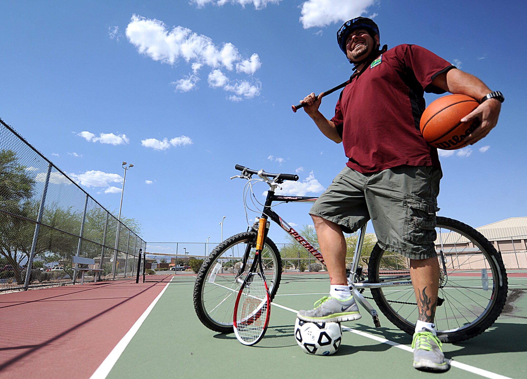 Vincent Tracy, 99th Force Support Squadron recreational aide, poses with various sports equipment and gear May 27, 2014 at Nellis Air Force Base, Nev.  Nellis members are reminded to take all necessary precautions to avoid injuries, including wearing required safety gear and staying properly hydrated.    From June 2009 to September 2013, there were more than 4,000 sports-related injuries reported Air Force-wide.  Sports safety is one of the key focuses of this year’s Critical Days of Summer campaign.  (U.S. Air Force photo by Senior Airman Siuta B. Ika)