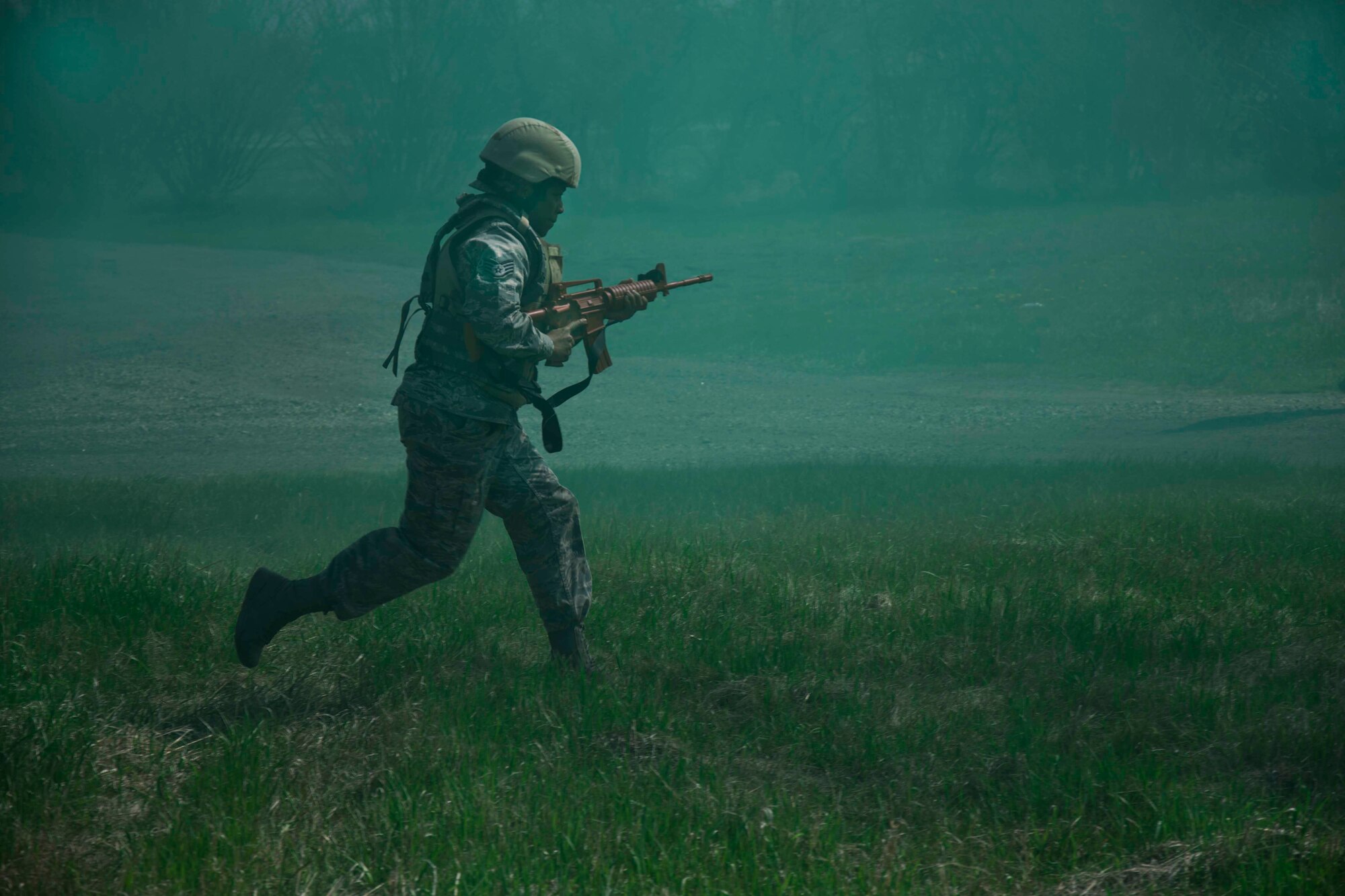 An Airman from the 5th Civil Engineer Squadron runs through a field of smoke during an exercise at Minot Air Force Base, N.D., on May 21, 2014. The exercise was part of pre-deployment training. (U.S. Air Force photo/Airman Class Lauren Pitts) 