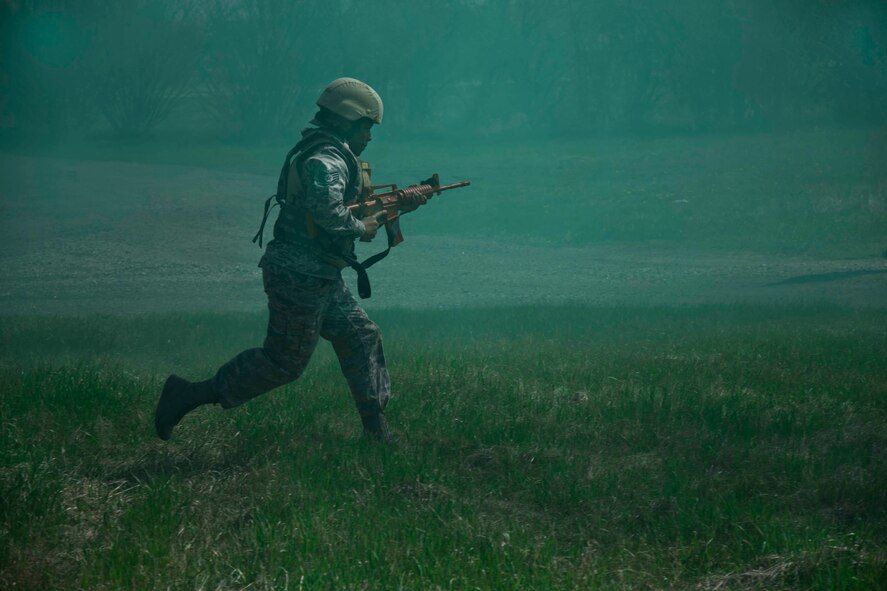 An Airman from the 5th Civil Engineer Squadron runs through a field of smoke during an exercise at Minot Air Force Base, N.D., on May 21, 2014. The exercise was part of pre-deployment training. (U.S. Air Force photo/Airman Class Lauren Pitts) 