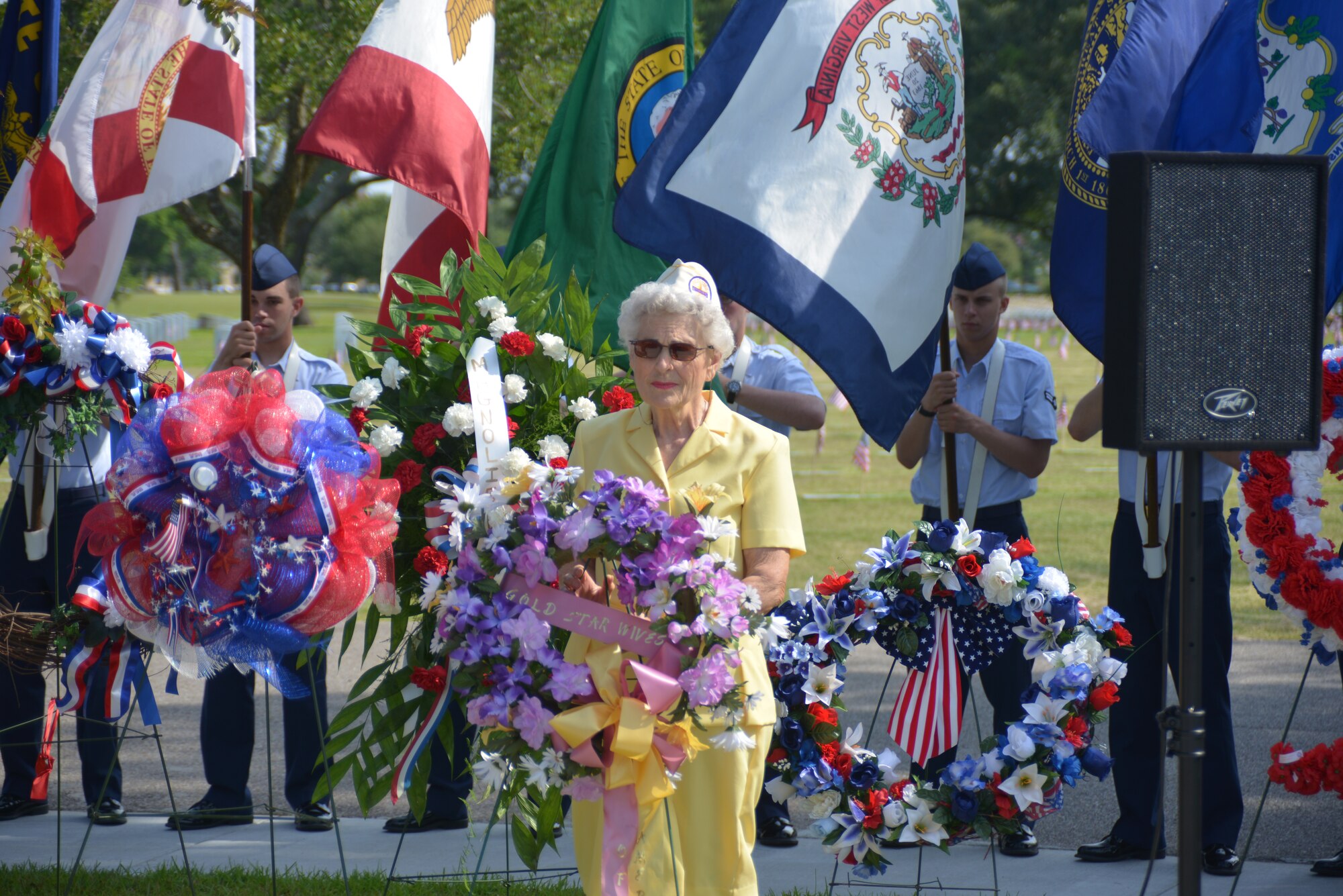 Emily Crower presents a wreath on behalf of the Gold Star Wives organization during a Memorial Day ceremony at the Biloxi National Cemetery May 26, 2014. Brig. Gen. Patrick Higby, 81st Training Wing commander, Keesler Air Force Base, Miss., was the keynote speaker for the event.  Higby spoke to more than 200 community representatives, veterans and family members about the many sacrifices made by veterans and the price of freedom today.  Airmen from the 81st Training Group holding the 50 state flags also participated in the event. (U.S. Air Force photo by Richard Meuse)