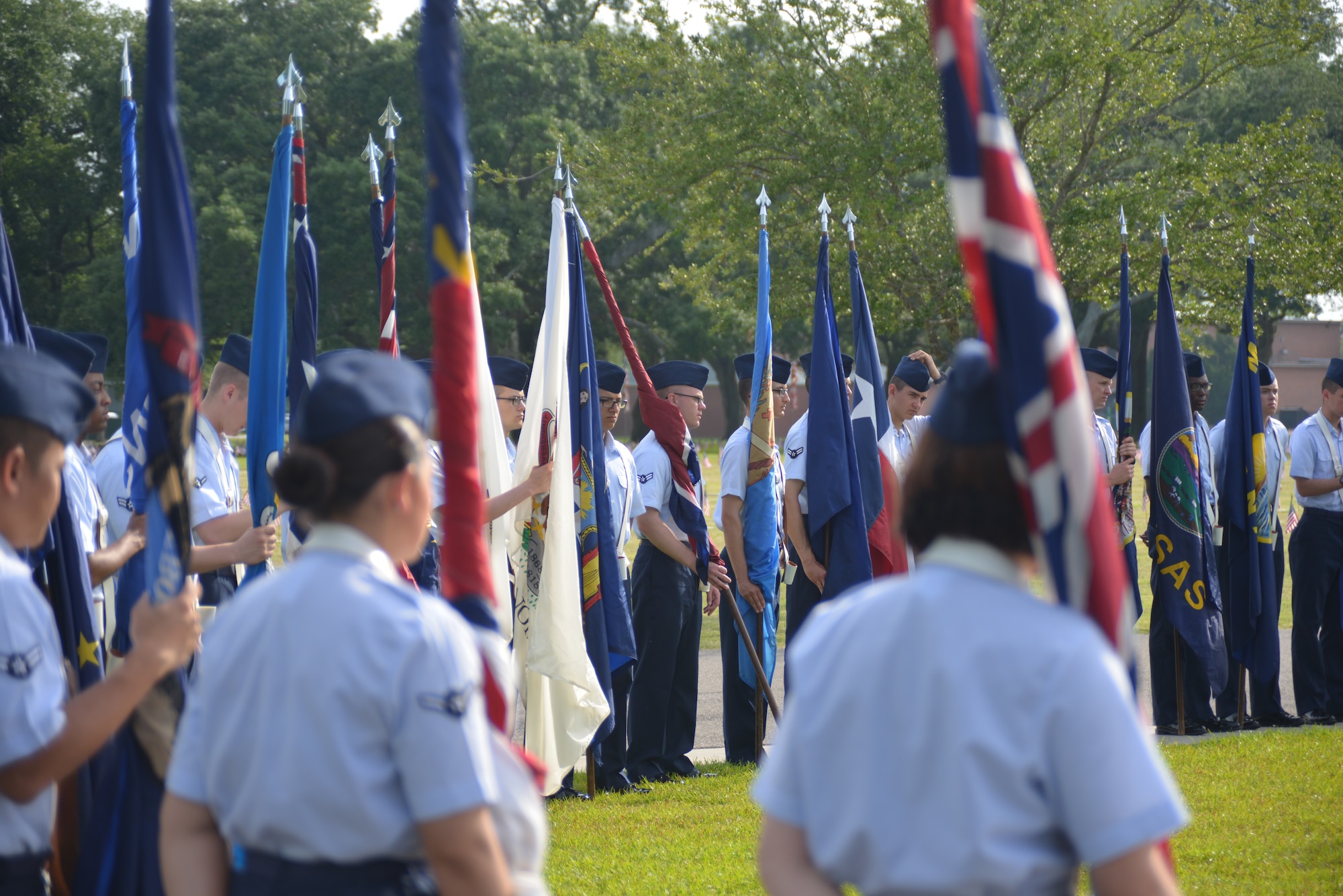 Airmen from the 81st Training Group, Keesler Air Force Base, Miss., hold the 50 state flags during a Memorial Day ceremony at the Biloxi National Cemetery May 26, 2014. Brig. Gen. Patrick Higby, 81st Training Wing commander, was the keynote speaker for the event.  Higby spoke to more than 200 community representatives, veterans and family members attend about the many sacrifices made by veterans and the price of freedom today.  (U.S. Air Force photo by Richard Meuse)