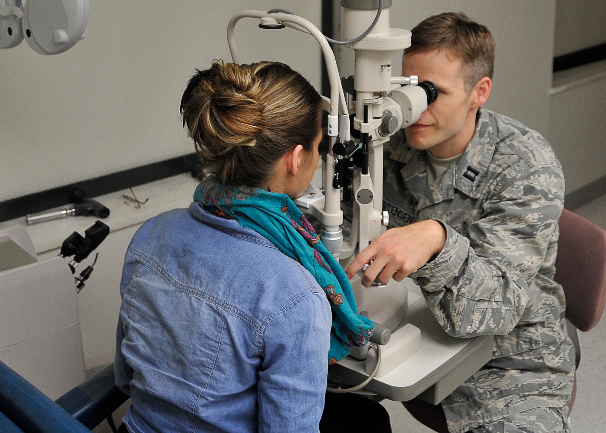 Capt. Todd Christensen, 325th Aerospace Medicine Squadron optometry flight commander, performs an eye exam on a patient May 21 at the optometry office. Airmen, retirees and dependents can receive eye exams as part of their medical benefits. (U.S. Air Force photo by Airman 1st Class Solomon Cook)