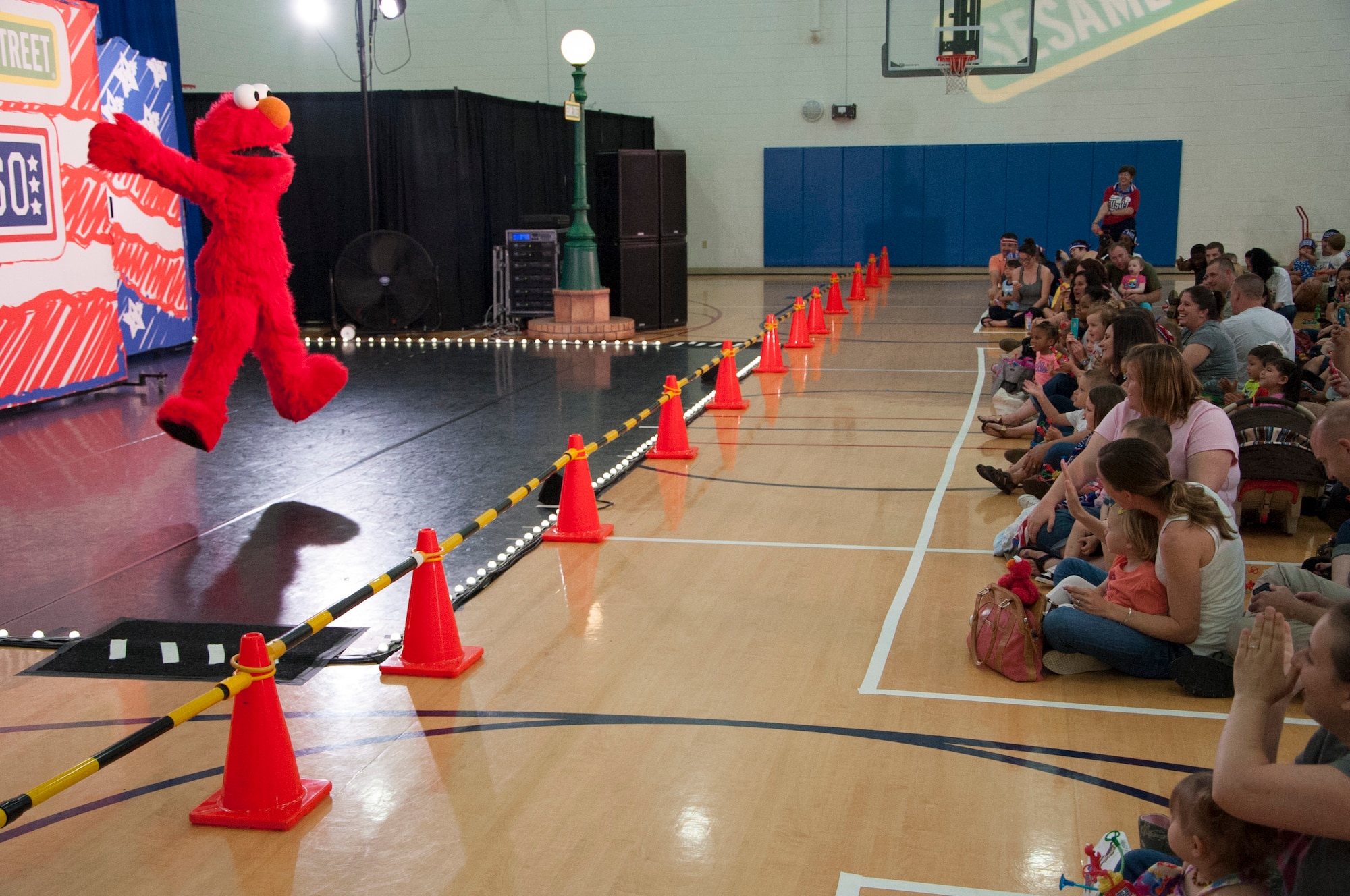 Elmo jumps while singing to children during Sesame Street live hosted by the United Service Organization May 22, 2014, at the Youth Center on Dover Air Force Base, Del. Elmo and his friends from the children’s series sang about resiliency, friendship and other positive themes to help children learn about different way to cope with military life. (U.S. Air Force photo/Senior Airman Jared Duhon) 