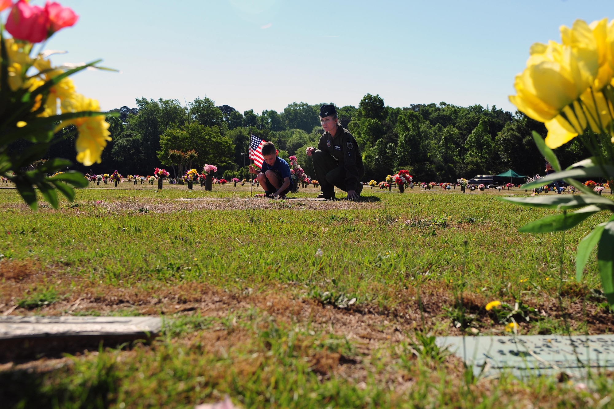Col. Jeannie Leavitt, 4th Fighter Wing commander, and her son place an American flag by a gravestone, May 24, 2014, at Wayne Memorial Park in Goldsboro, North Carolina. More than 800 flags were set by monuments in honor of Memorial Day. (U.S. Air Force photo/Senior Airman John Nieves Camacho)