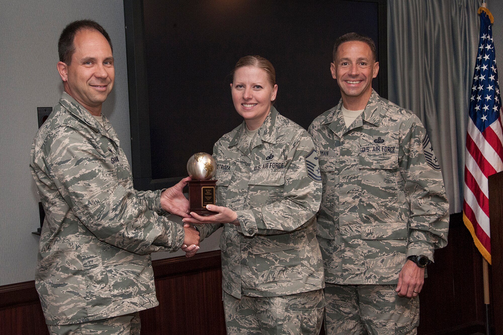 PETERSON AIR FORCE BASE, Colo. -- Col. John Shaw, 21st Space Wing commander, and Chief Master Sgt. Richard Redman, 21st Space Wing command chief, present the Air Force Space Command First Sergeant of the Year trophy May 7 to Master Sgt. Nancy Hinostroza, 21st Civil Engineer Squadron first sergeant. Hinostroza won the award while she was assigned as the 561st Network Operations Squadron first sergeant here. (U.S. Air Force photo/Craig Denton)
