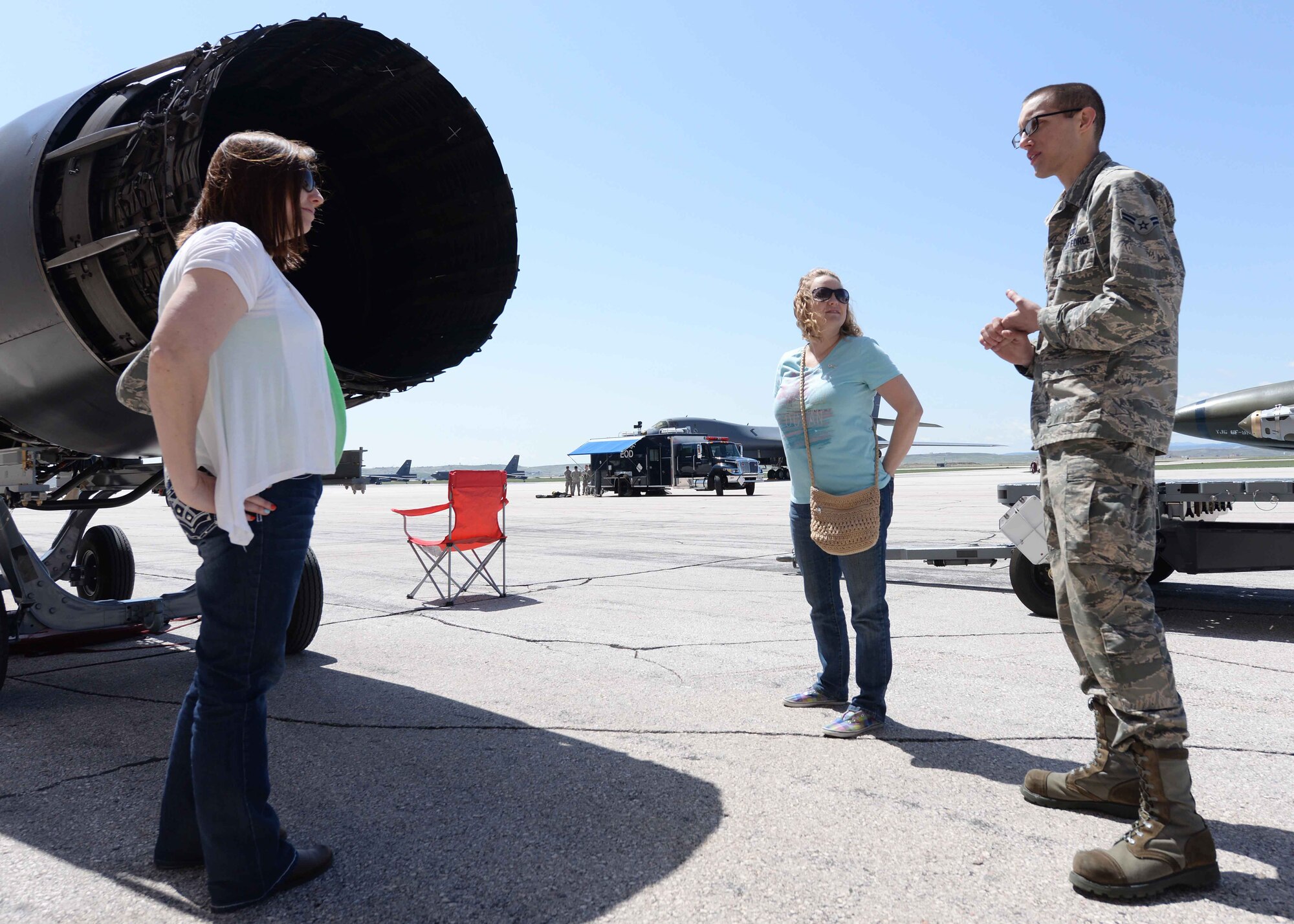 Melissa Detullio (left), wife of Tech. Sgt. Jason Detullio, 28th Maintenance Squadron assistant consolidated tool kit section chief, Betsy Combs, wife of Tech. Sgt. Brian Combs, 28th MXG isochronal support NCO in charge, and Airman 1st Class Tyler Carr, 28th Aircraft Maintenance Squadron aerospace propulsion technician, discuss the capabilities of a B-1 Bomber engine at Ellsworth Air Force Base, S.D. May 9, 2014. Many squadrons from base gave demonstrations and tours to with military spouses and their families. (U.S. Air Force photo by Airman 1st Class Rebecca Imwalle/ Released)
