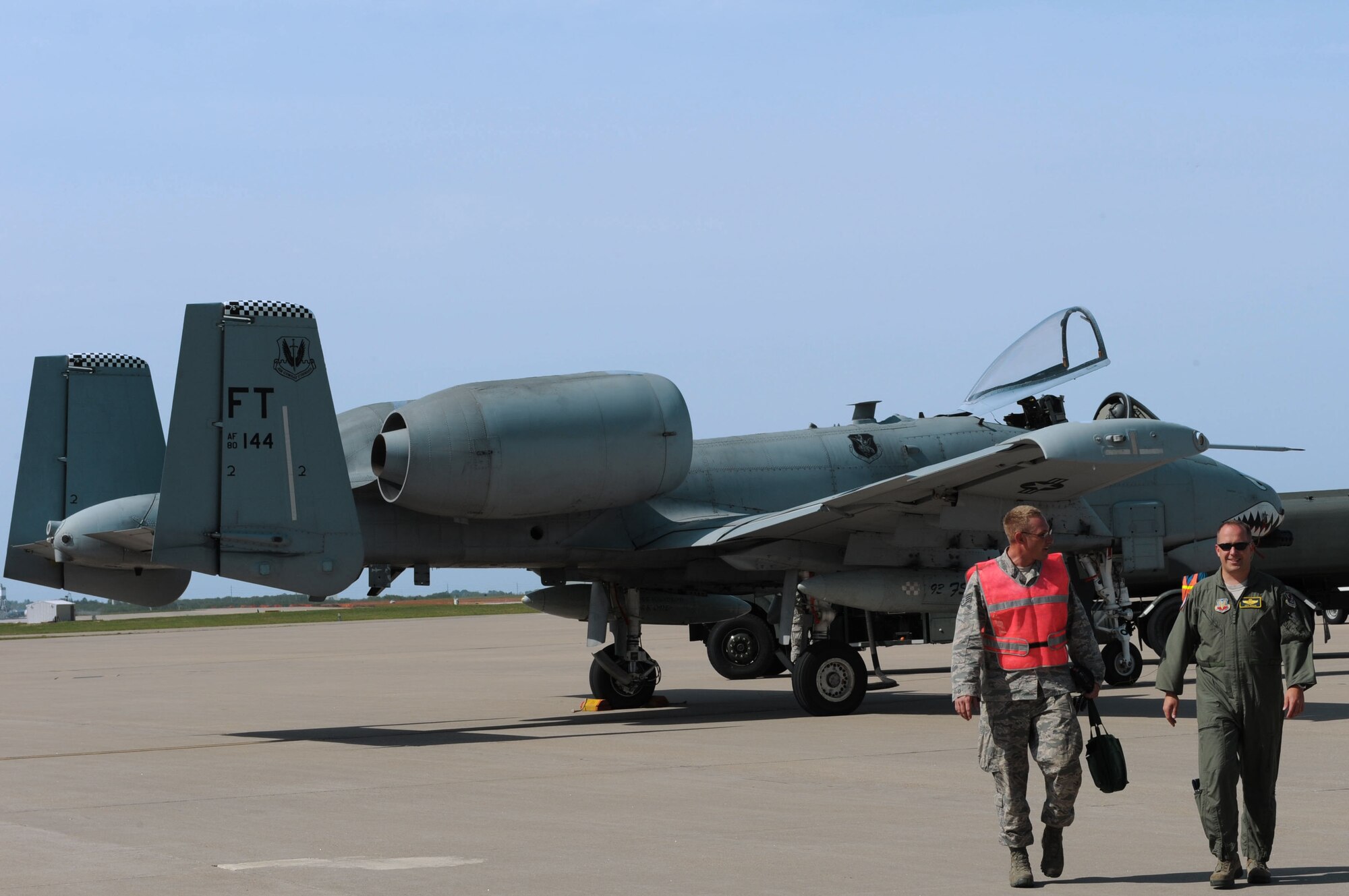 Lt. Col. Jeff Hogan, 23rd Fighter Group deputy commander, Moody Air Force Base, Ga., and Staff Sgt. Neil Oltmer, 22nd Civil Engineer Squadron structural journeyman, walk away from an A-10 Thunderbolt II, May 20, 2014, at McConnell Air Force Base, Kan. Hogan and Oltmer reunited to launch the aircraft on its final flight en route to the Davis-Monthan Air Force Base, Ariz., Aircraft Boneyard. Oltmer was a dedicated crew chief for the retiring A-10 before cross-training to the Civil Engineer career field. (U.S. Air Force photo/Airman 1st Class David Bernal Del Agua)