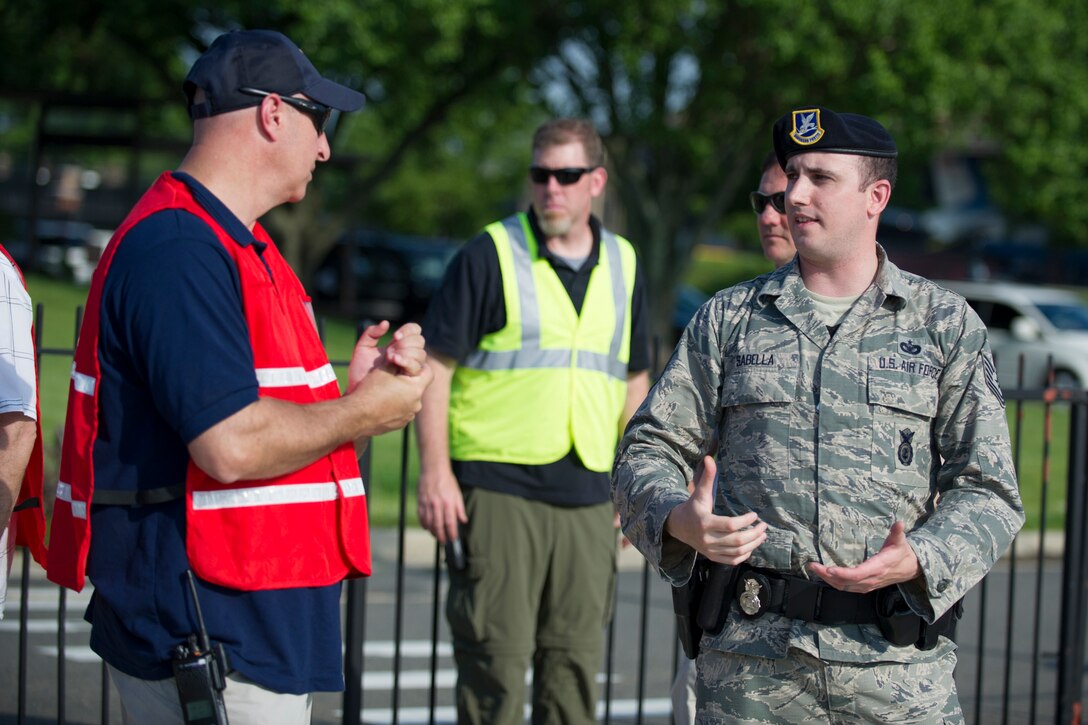 Tech. Sgt. Frank Sabella (right), 811th Security Forces Squadron Protective Services element leader, briefs United States Secret Service Special Agent Ed Sebring (left) after a training scenario on the Joint Base Andrews flight line. The two-day training was the first large-scale contingency response exercise between Joint Base Andrews and the USSS. (U.S. Air Force Photo/Staff Sgt. Robert Cloys)