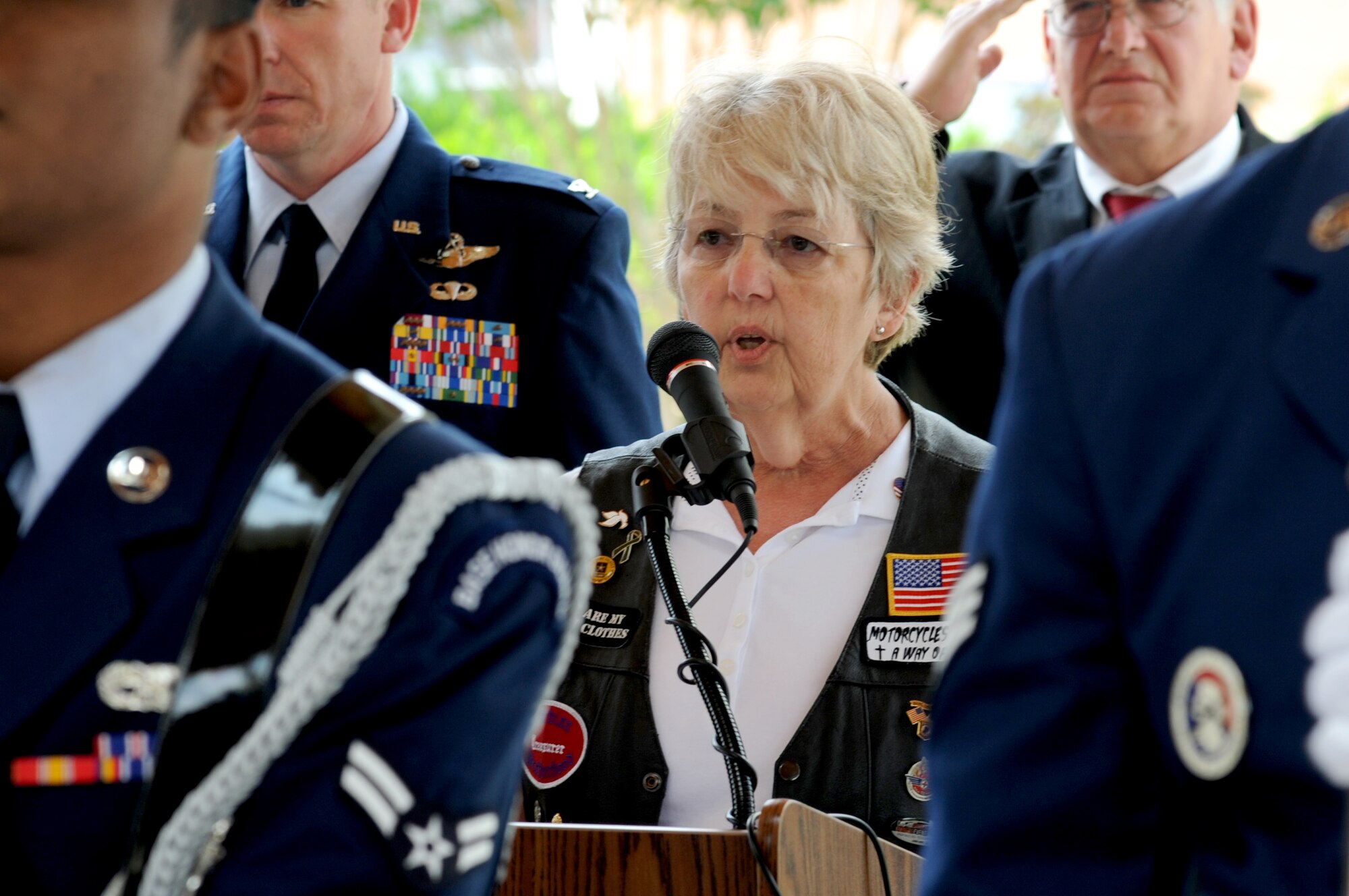 Kris Brewer, soloist, sings the National Anthem, as members of the 4th Fighter Wing Honor Guard present the colors, May 26, 2014, during the observance of the National Moment of Silence at the Wayne County Veteran’s Memorial in Goldsboro, North Carolina. The Moment of Silence encourages all Americans to pause on Memorial Day to honor and remember those who have died in service to the nation. (U.S. Air Force photo/Senior Airman Mariah Tolbert)